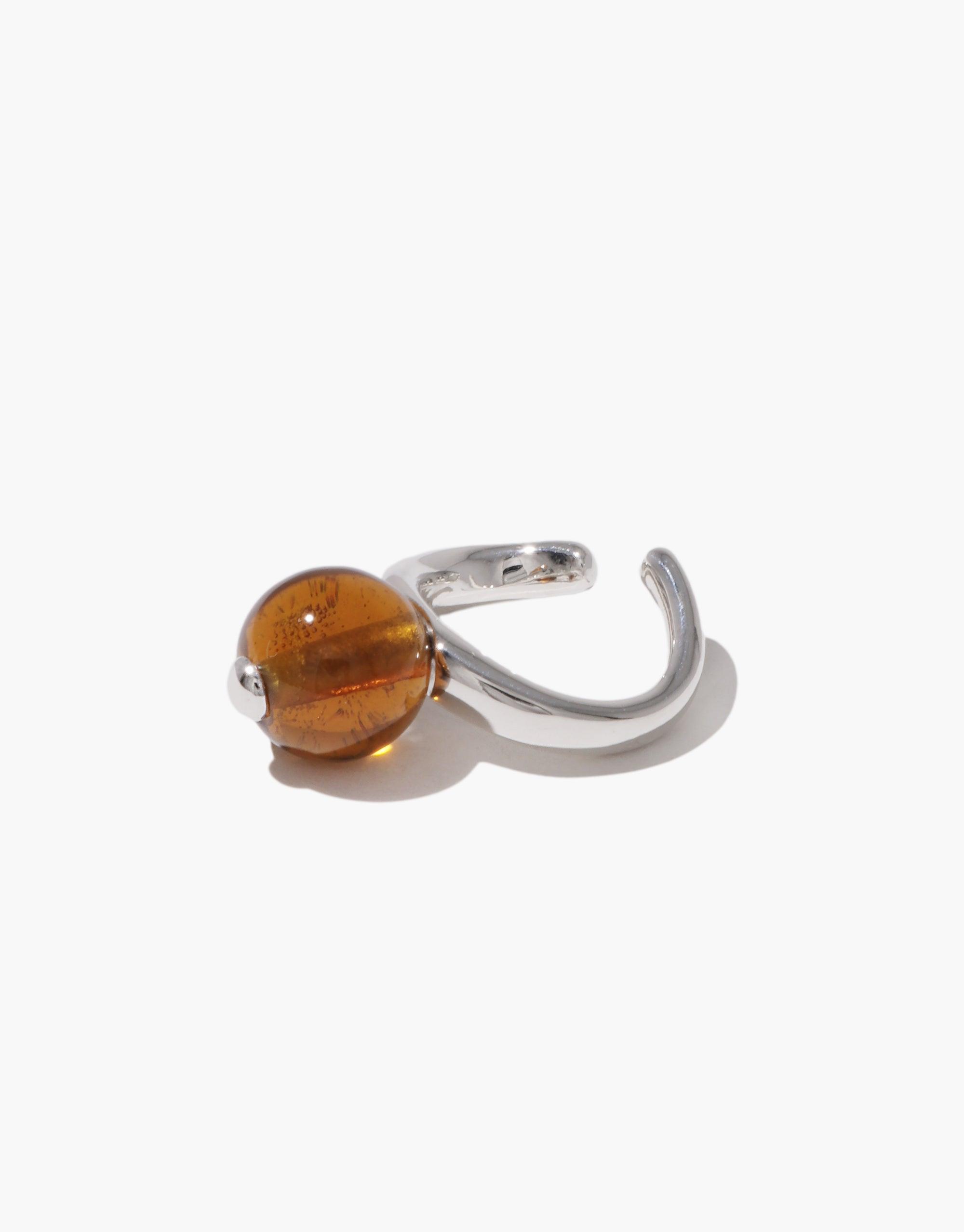 Stylish Pea Ear Cuff | Large featuring a sleek silver-toned curved design with an amber-colored spherical bead, inspired by organic legume shapes, showcasing nature's beauty and growth. Elegant accessory for a touch of natural sophistication. CLED