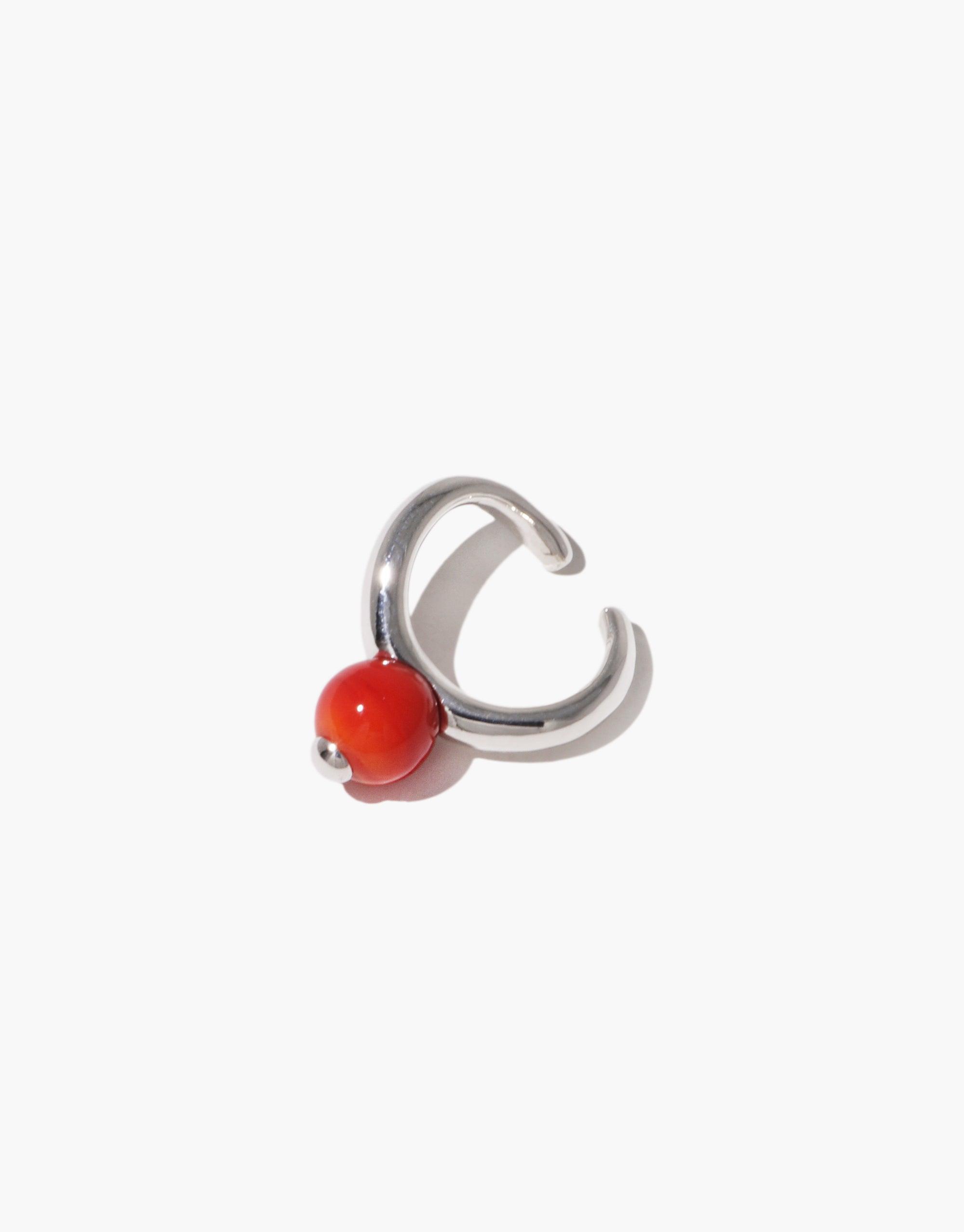 Sleek silver ear cuff with vibrant red bead, inspired by nature's organic forms. Elegant and minimalist design for a subtle yet stylish accessory. Pea Ear Cuff | Small, perfect for everyday wear or special occasions. CLED