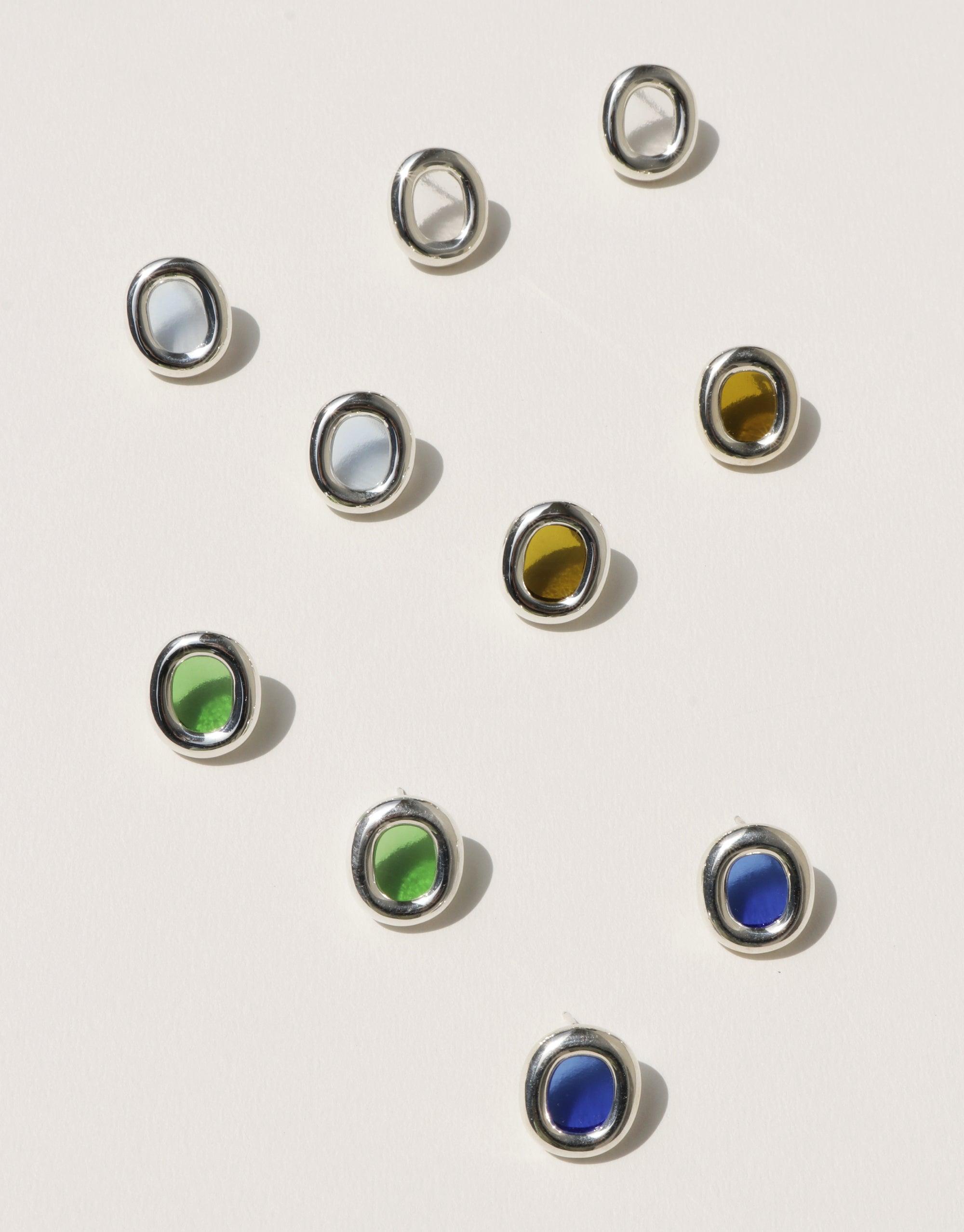 Minimalist silver hoop earrings with colorful glass inserts in green, blue, yellow, and clear, arranged artfully on a white background. Sustainable jewelry design showcasing upcycled materials. Core Loop Earrings | Large by CLED
