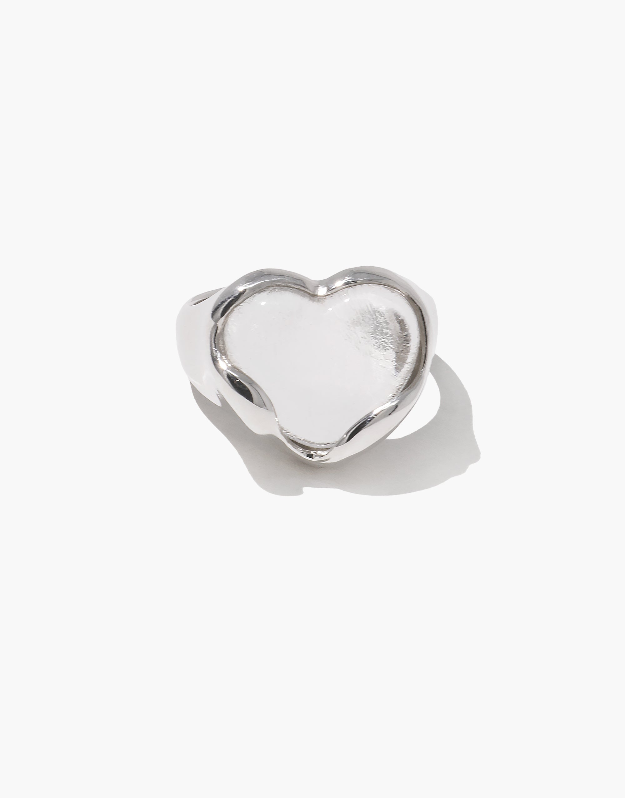 Front view of a minimal silver ring featuring a translucent heart centerpiece that reflects light with a soft shimmer.