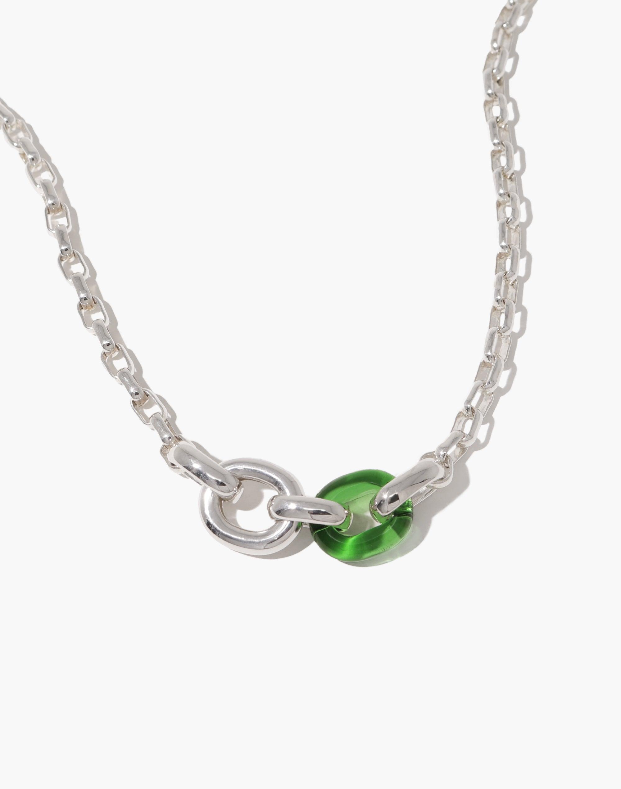 Loop Chain Necklace featuring a silver-toned chain with interlocking loops, showcasing a unique green glass bead centerpiece. This elegant upcycled design symbolizes unity and connection, embodying the In The Loop collection's ethos. A sustainable and stylish accessory by CLED.