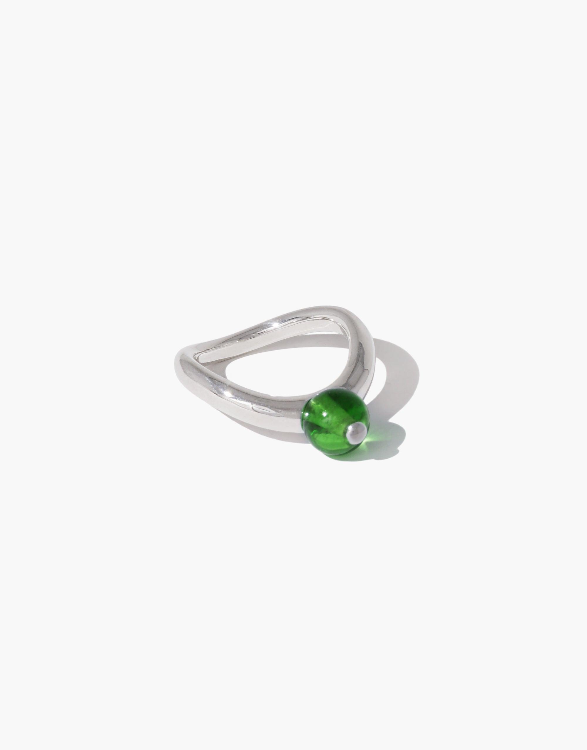 Elegant silver ring with curved design featuring a vibrant green bead, inspired by organic legume shapes. Pea Curve Ring | Small showcases nature-inspired jewelry art. CLED