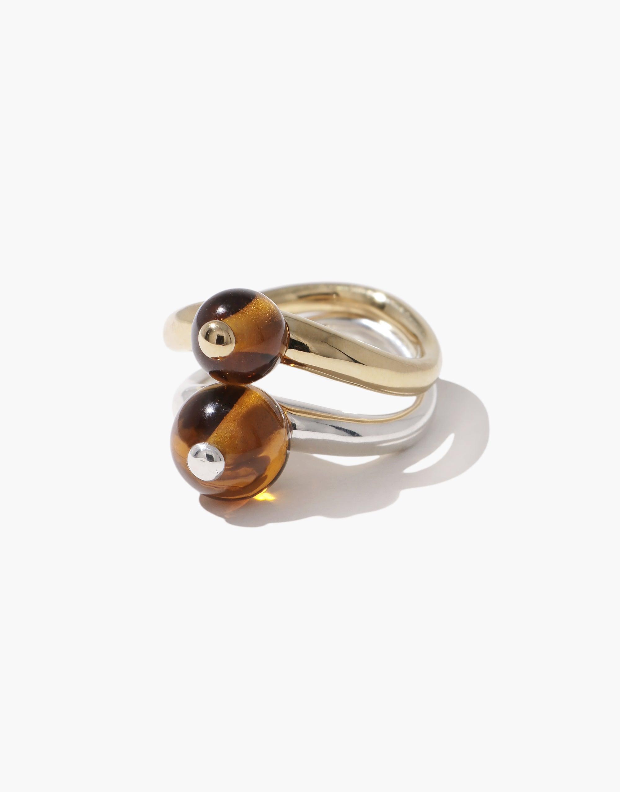 Elegant Pea Curve Ring featuring two amber-colored spheres on curved silver and gold bands, inspired by nature's organic shapes. Unique design showcases the beauty of legume-inspired jewelry. Pea Curve Ring | Small by CLED