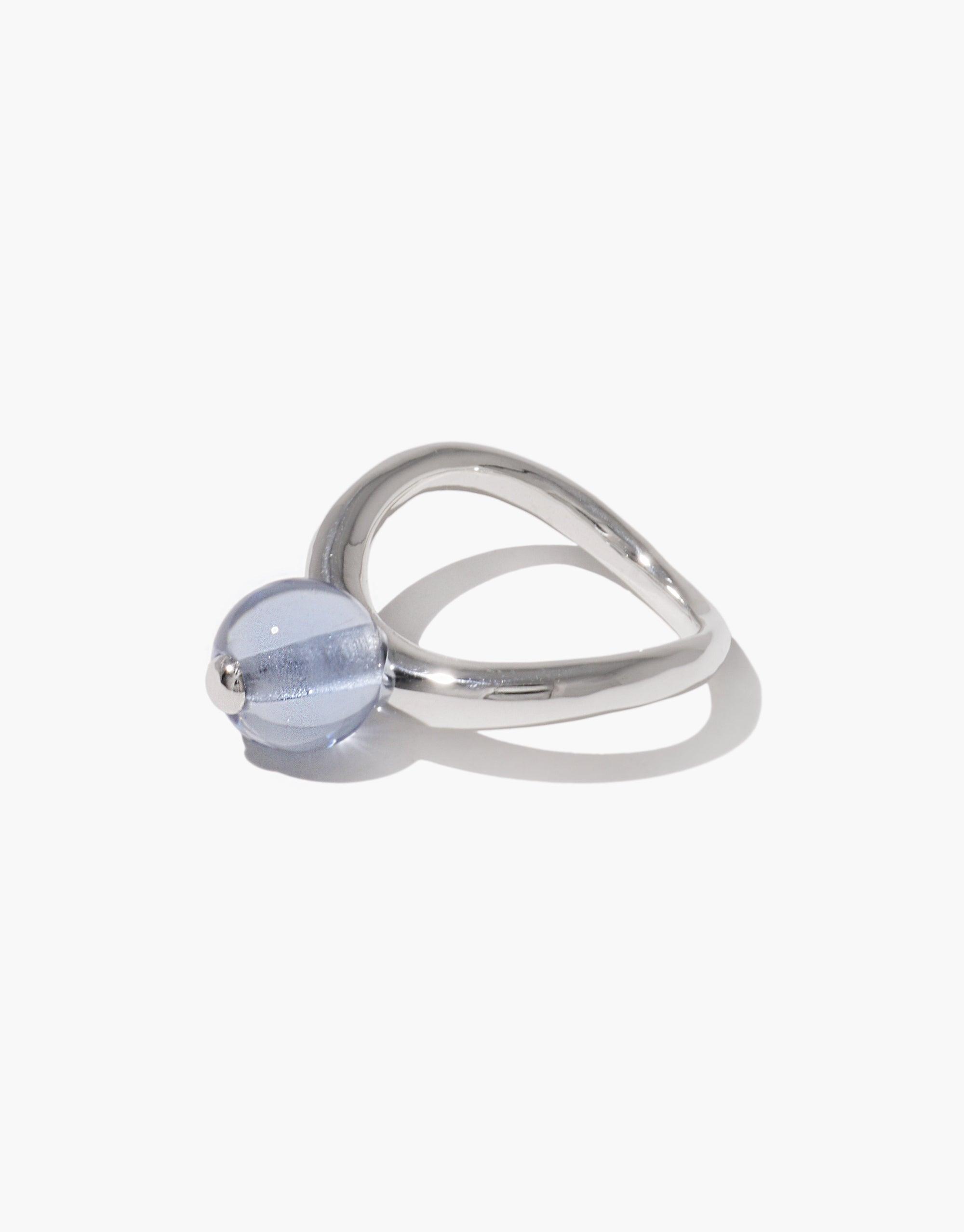 Elegant silver ring with curved design and light blue glass bead, inspired by organic pea pod shapes. Pea Curve Ring | Large showcases nature-inspired jewelry craftsmanship. CLED