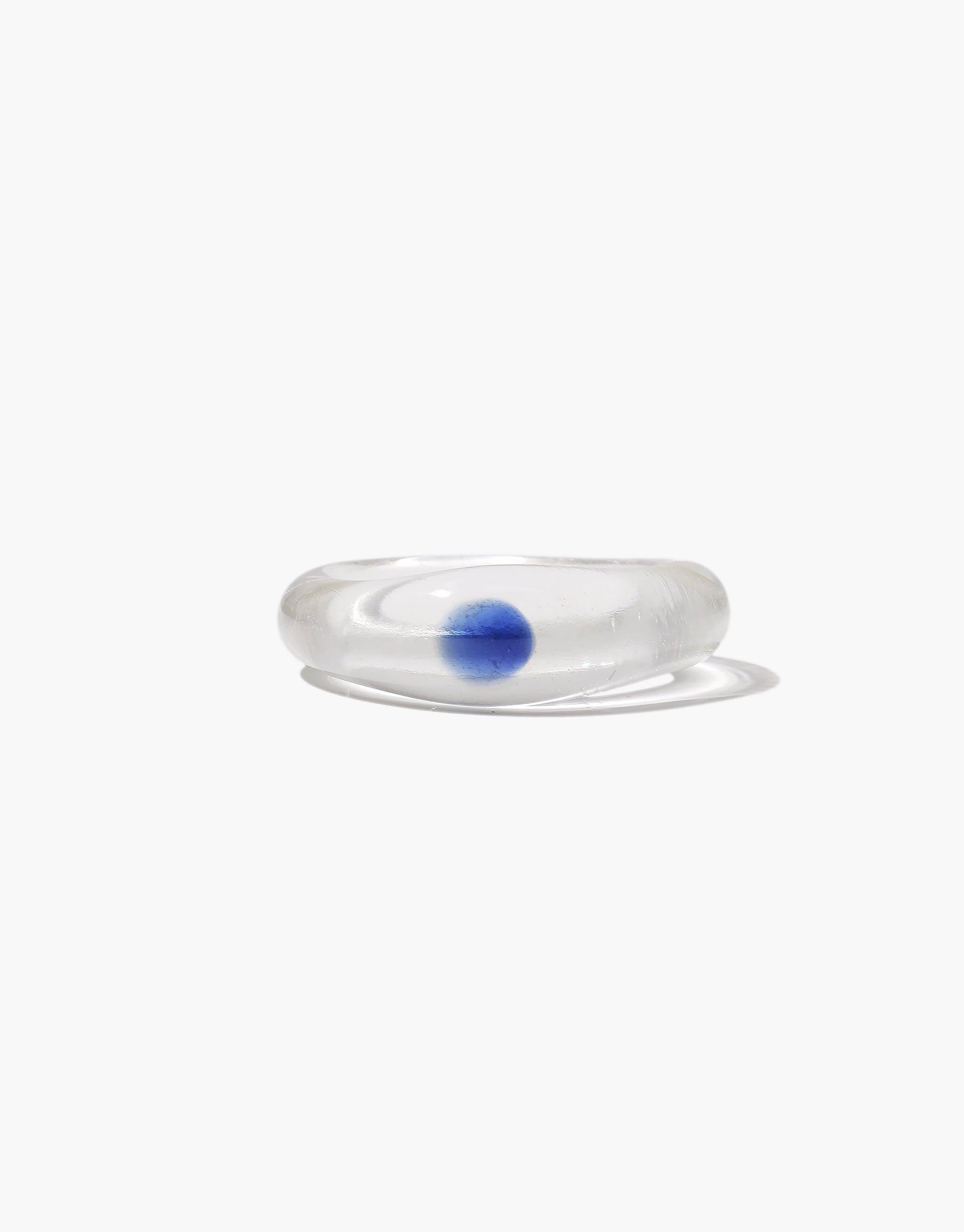 Clear glass ring with a vibrant blue sphere embedded inside, showcasing the unique and enchanting design of the Blue Moon Ring. Elegant and minimalist jewelry piece capturing the essence of celestial beauty. CLED Blue Moon Ring