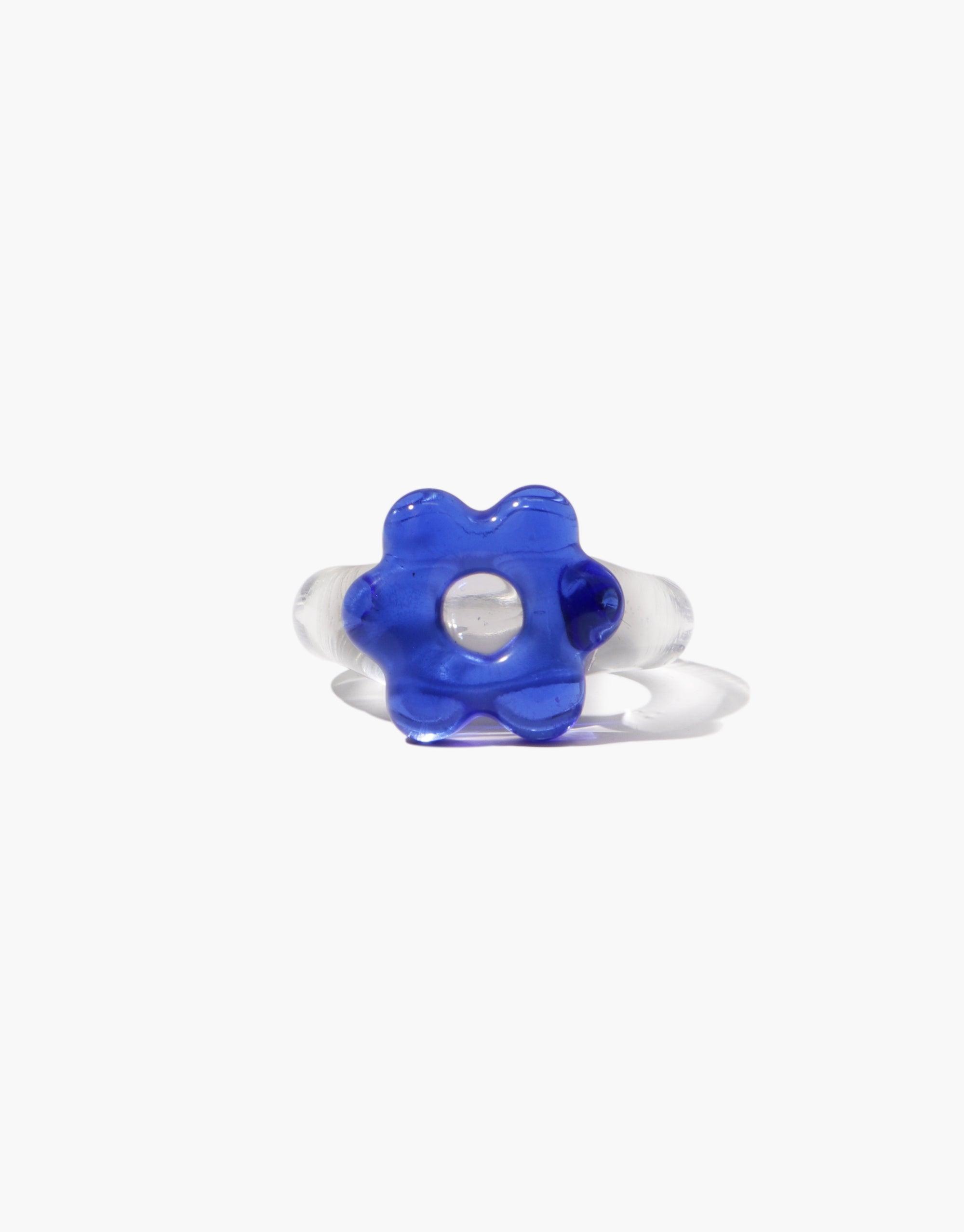 Avens Icon Ring | Large featuring a vibrant blue flower-shaped glass centerpiece on a clear band. Whimsical and eye-catching design perfect for statement jewelry lovers. Unique handcrafted accessory showcasing artisanal glasswork. CLED