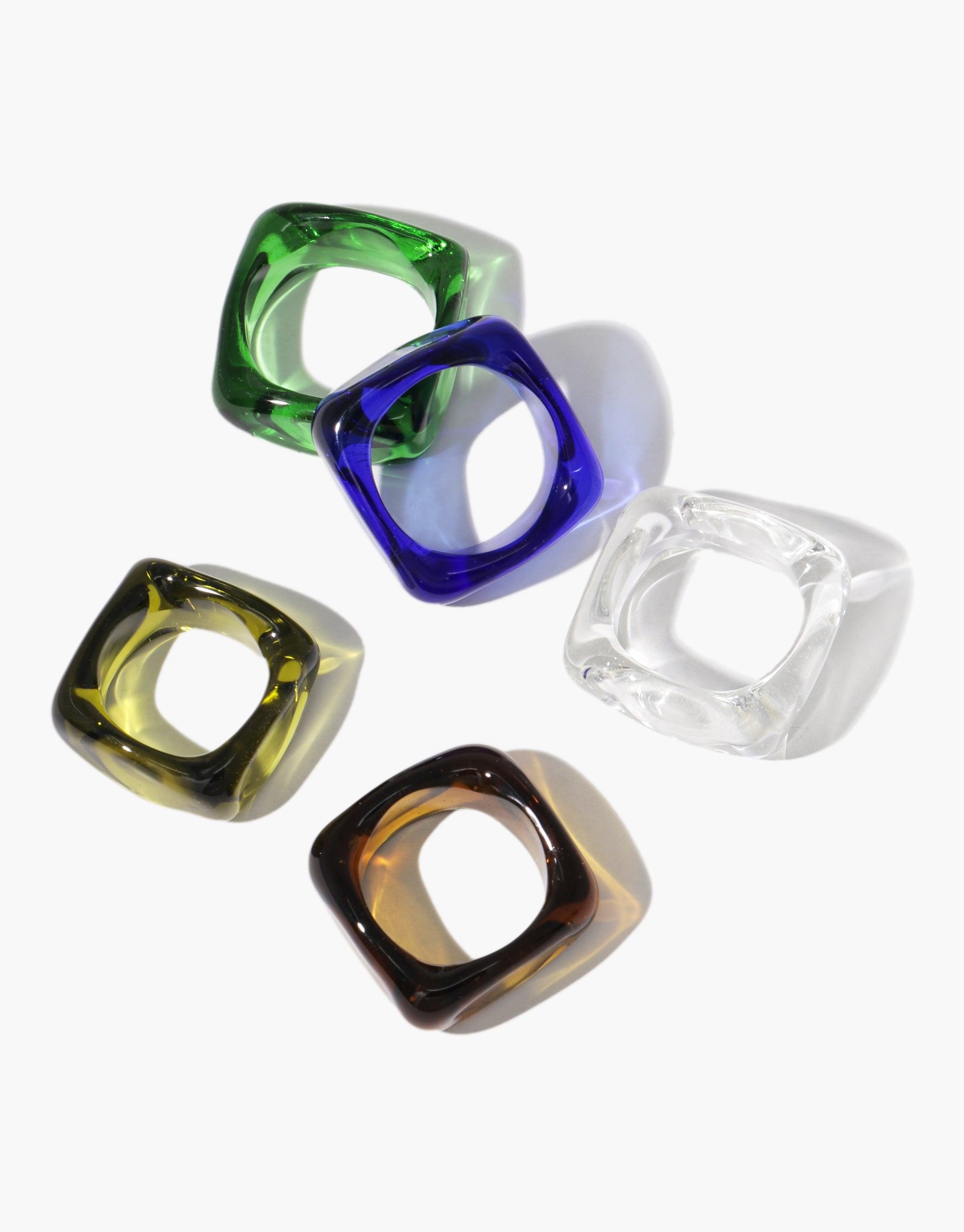 Colorful square glass rings in green, blue, yellow, clear, and amber arranged on a white background. Unique decision-making accessory for stylish choices. Dice Ring Yes or No by CLED