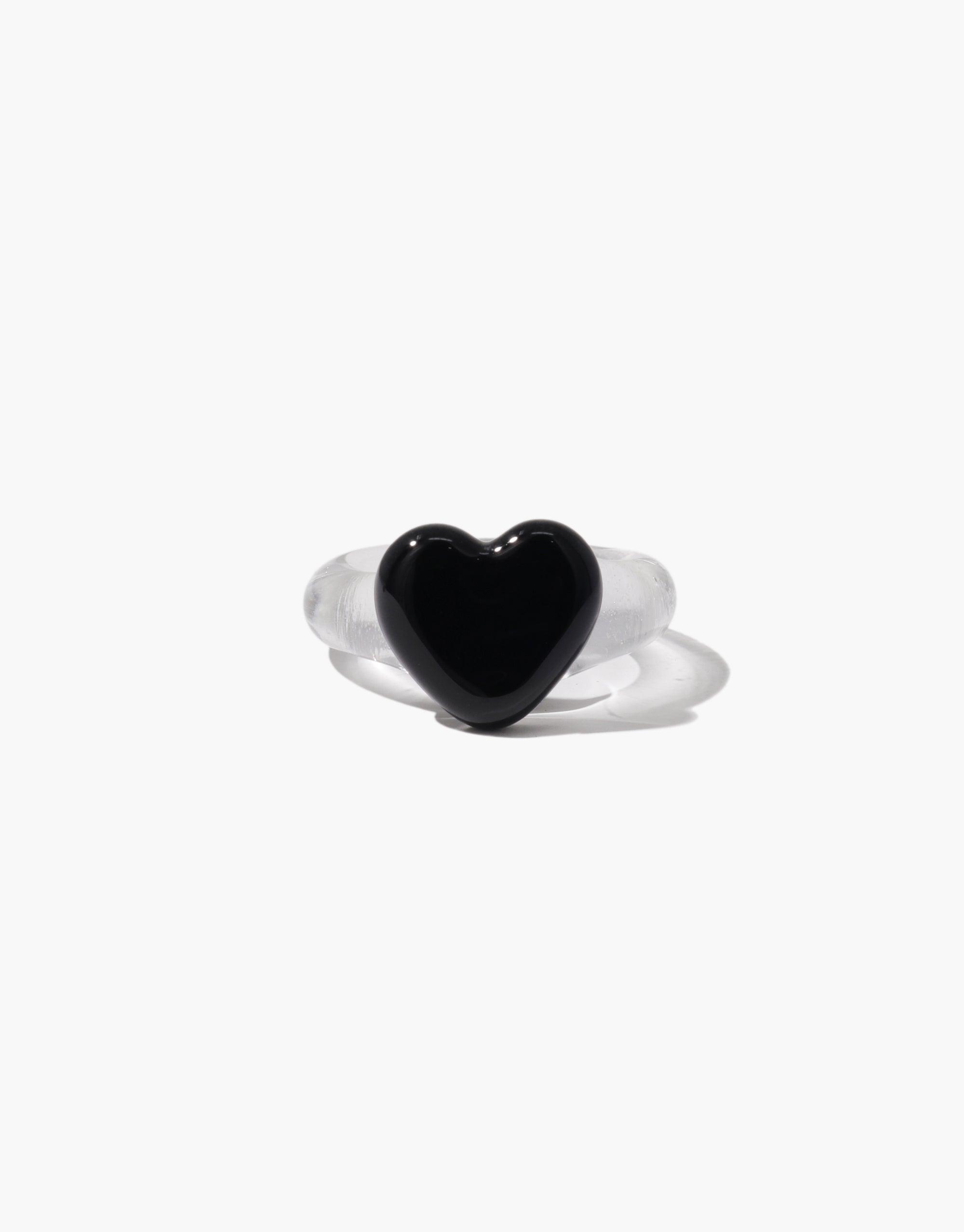 Heart Icon Ring | Large featuring a sleek black heart-shaped centerpiece on a clear transparent band. Elegant and minimalist design perfect for everyday wear or special occasions. Stylish accessory showcasing love and affection. CLED
