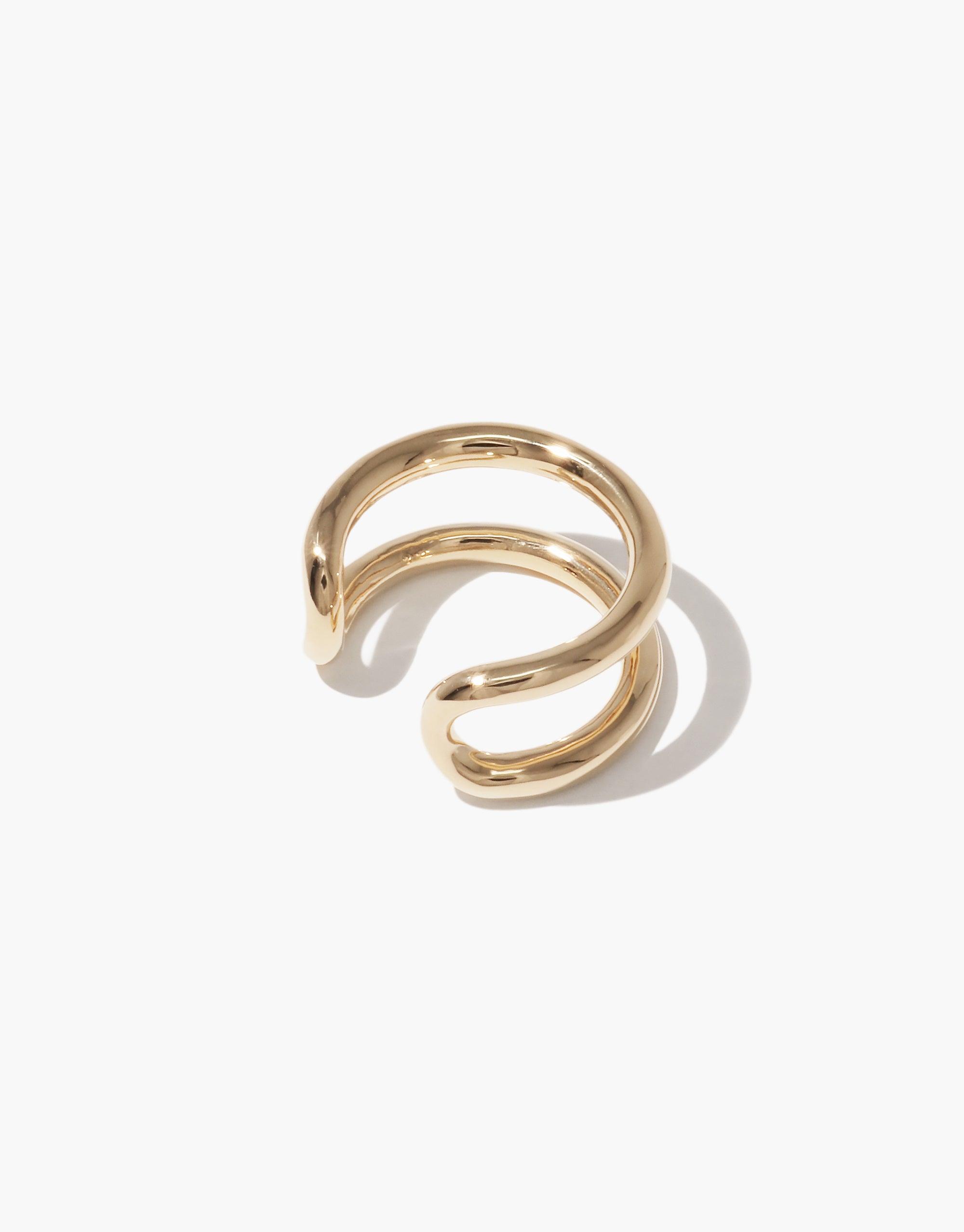 Gold-toned open spiral ring with smooth, curved design resembling an infinite loop. Elegant and minimalist jewelry piece symbolizing unity and continuity. Upcycled material showcases sustainability in fashion accessories. Infinite Loop Ring by CLED.