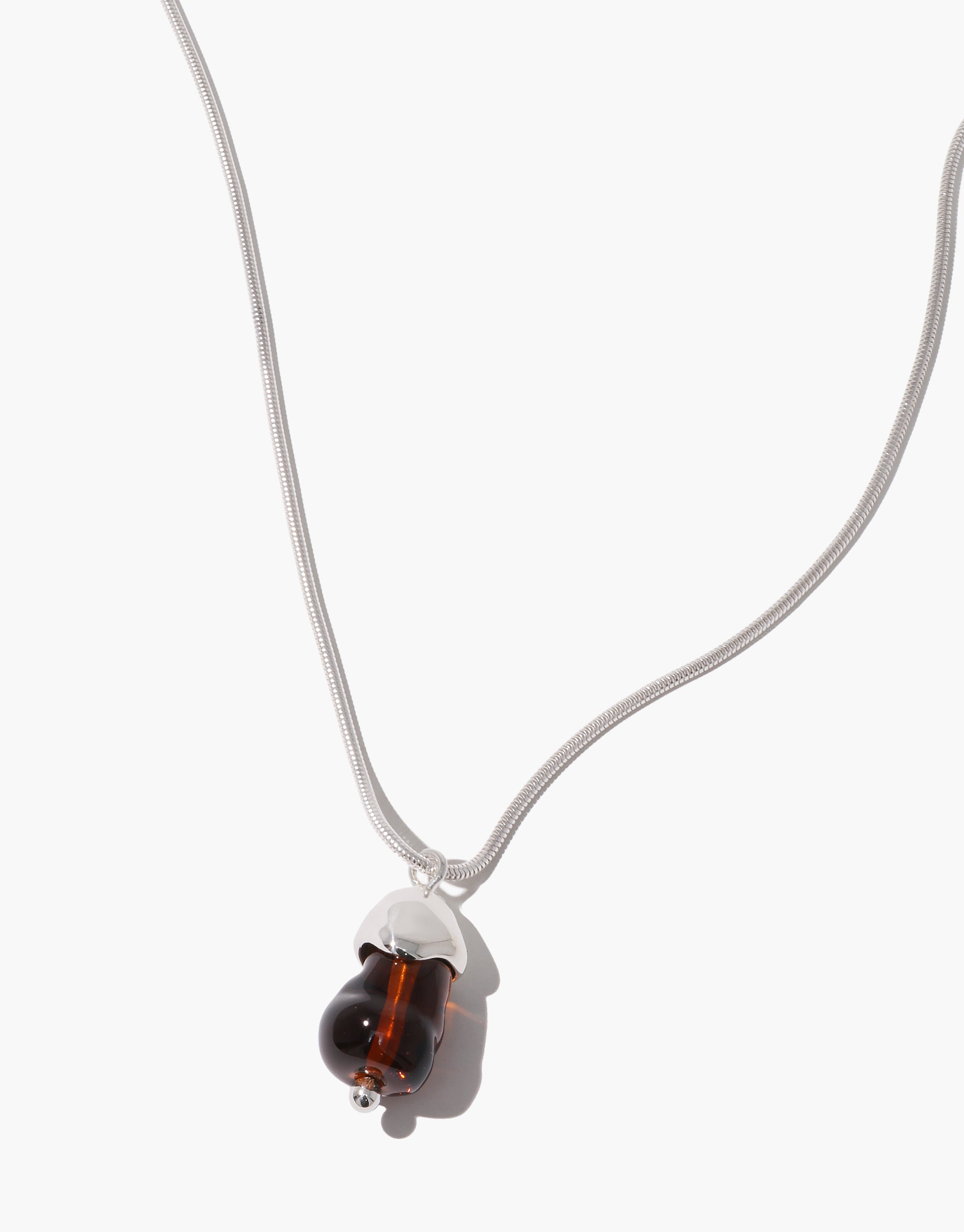 Solace Drop Necklace featuring clear and amber glass pendant on silver snake chain, minimalist design by CLED