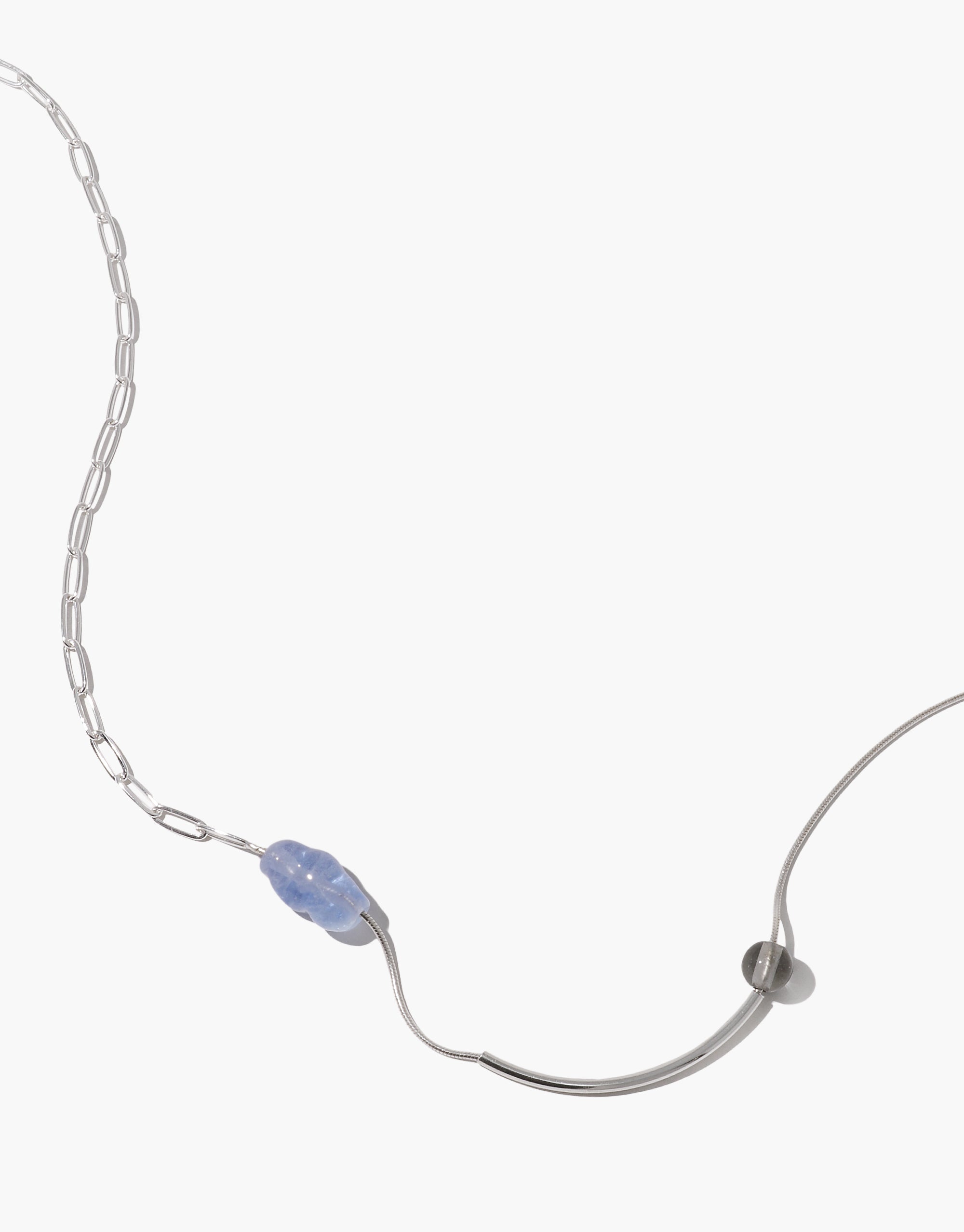 Still Necklace with asymmetric silver curves and blue glass bead on delicate chain links, showcasing fluid minimalist design by CLED