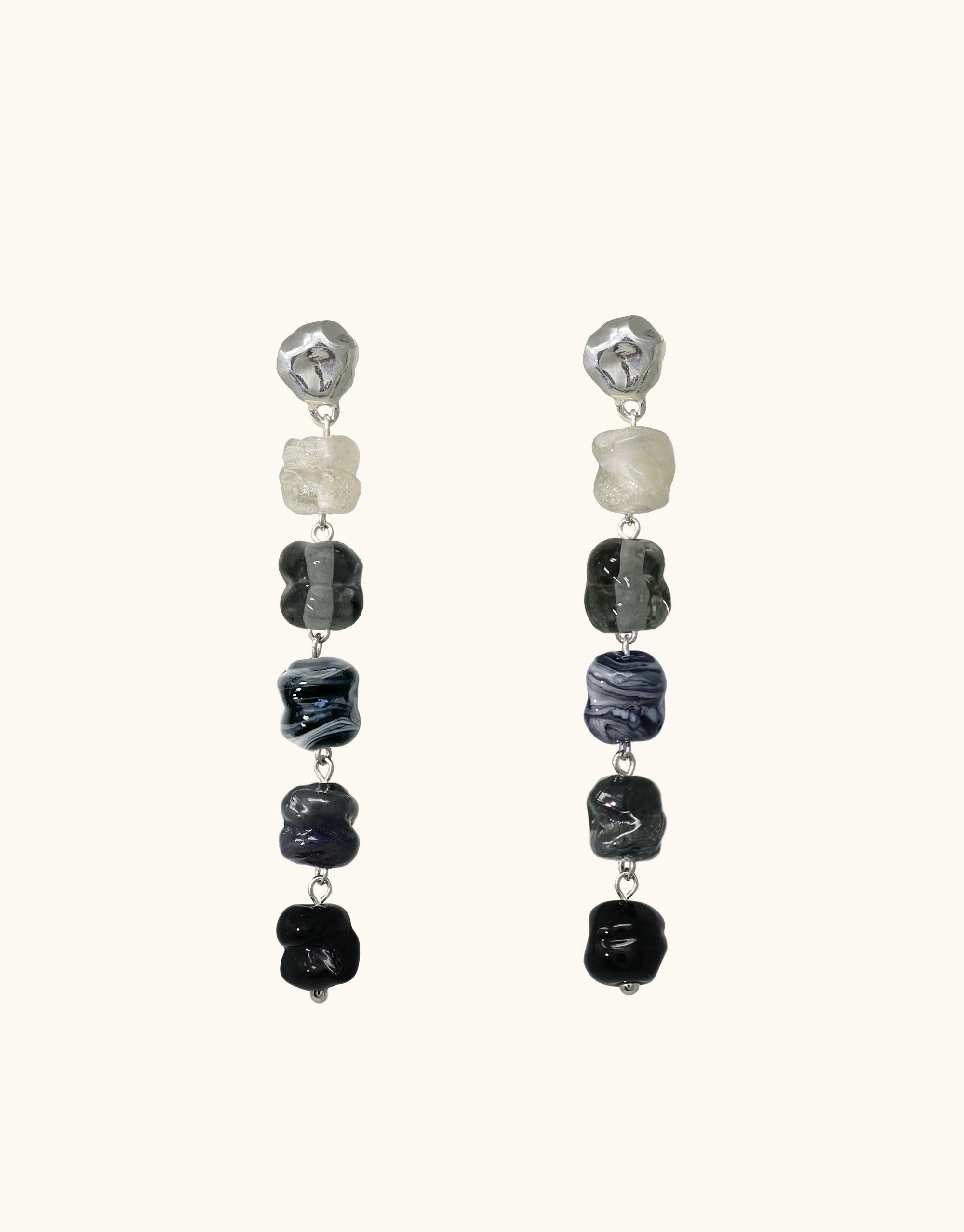 Elegant dangle earrings featuring gradient-colored glass beads from light to dark, inspired by basalt volcanic canyons. Handcrafted design with eco-friendly materials, showcasing unique textures and shapes. Shades of Nature | Basalt Earrings by CLED
