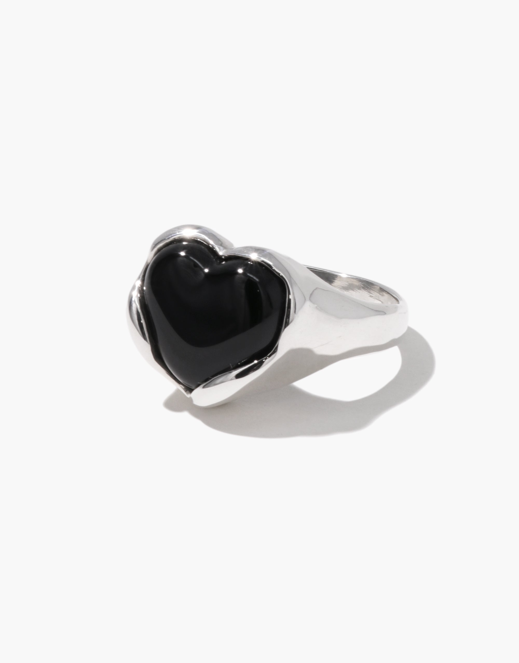 Angled side view of a silver ring featuring a glossy black heart-shaped Eco Gem set in a smooth, flowing band.
