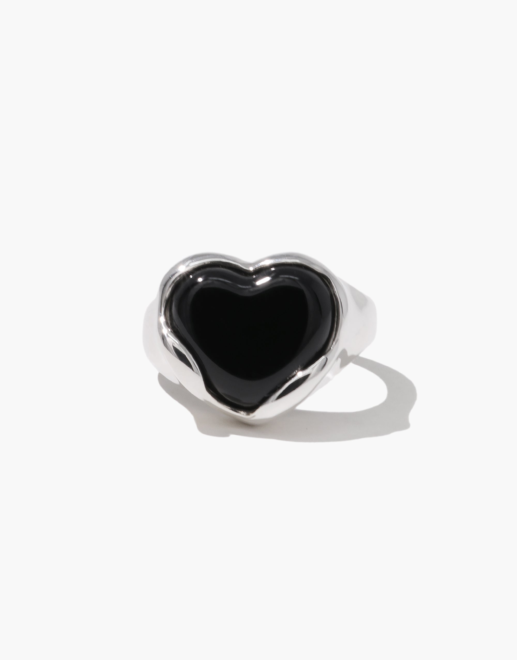 Front-facing view of a silver ring with a bold black heart centerpiece, designed with soft curves and a polished finish.