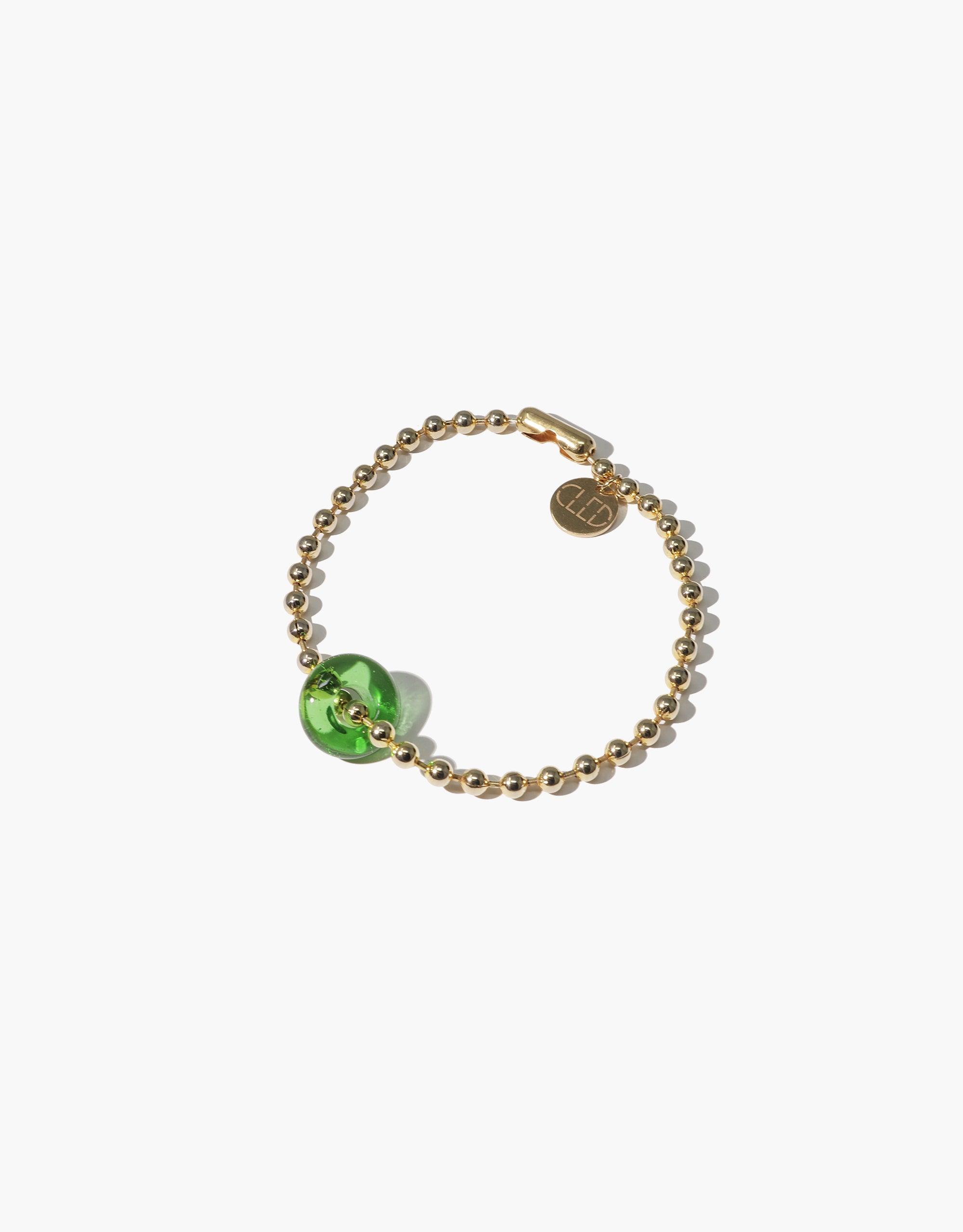 Donut Ball Bracelet featuring gold-toned beaded chain with a vibrant green eco-gem centerpiece, showcasing sustainable luxury and prismatic beauty. Handcrafted design with circular brand charm, perfect for eco-conscious fashion lovers. CLED Donut Ball Bracelet.