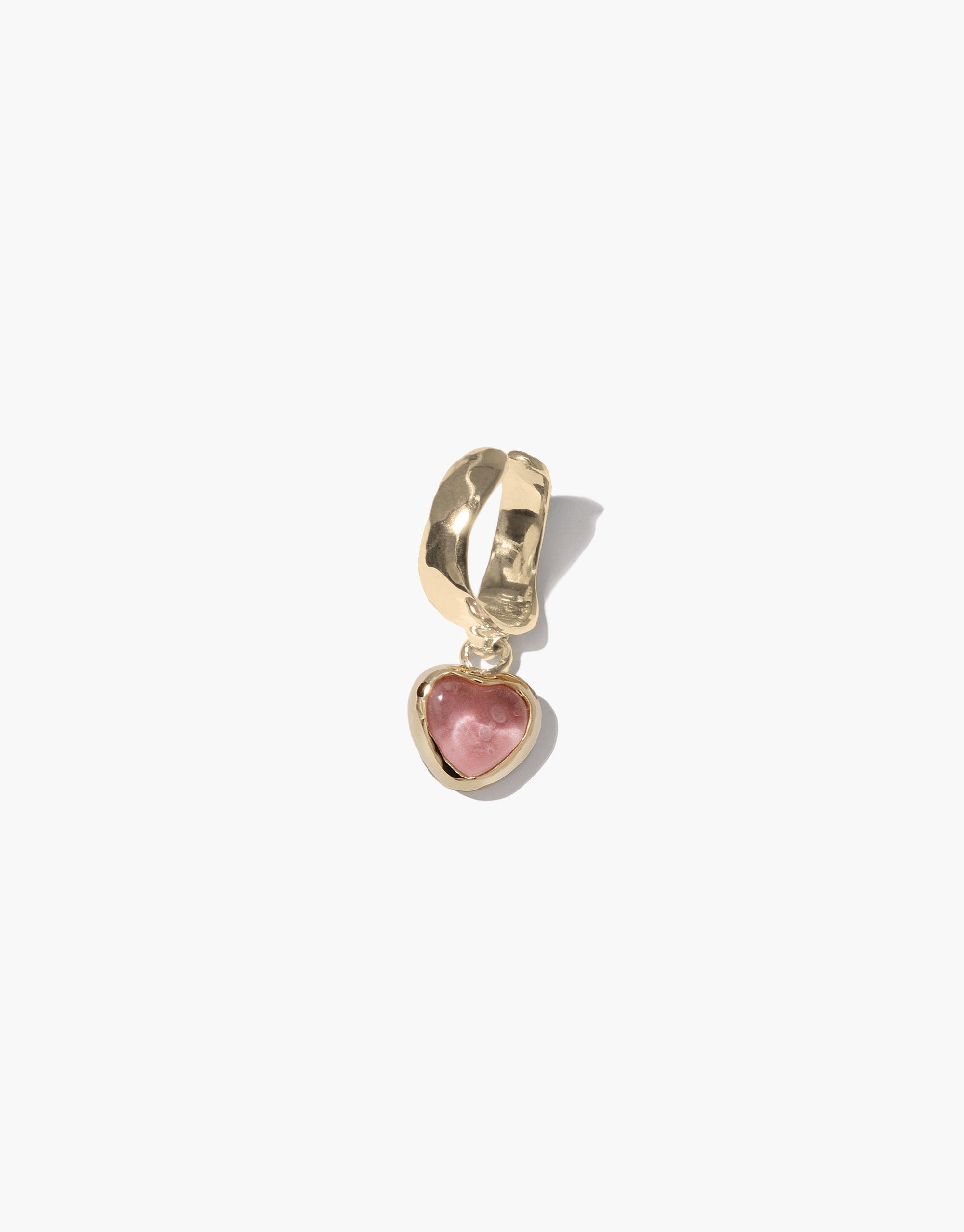 Gold-toned ear cuff with dangling pink heart charm, showcasing delicate craftsmanship and a romantic design. Heart Dangling Ear Cuff features upcycled eco-friendly materials, perfect for sustainable fashion lovers. Handmade jewelry by CLED.