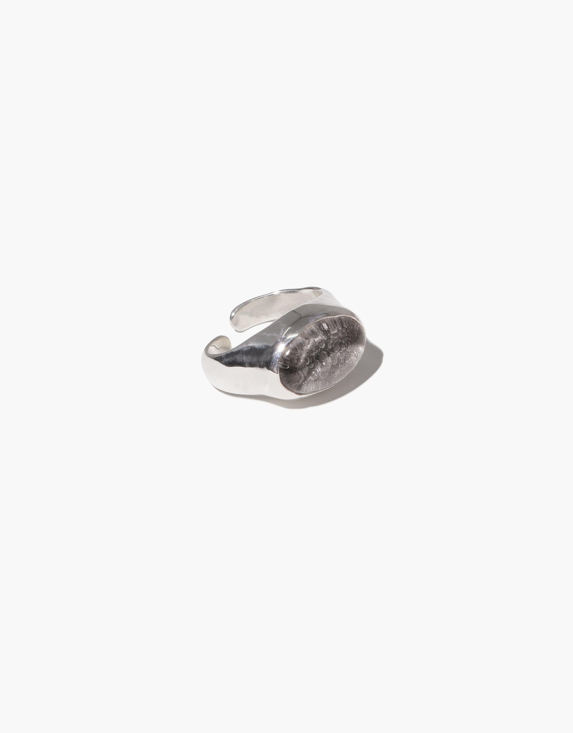 Oval Sculpture Ear Cuff with unique upcycled glass charm, handcrafted in sterling silver. Elegant and eco-friendly design showcasing a curved, organic shape. Sustainable jewelry piece by CLED.