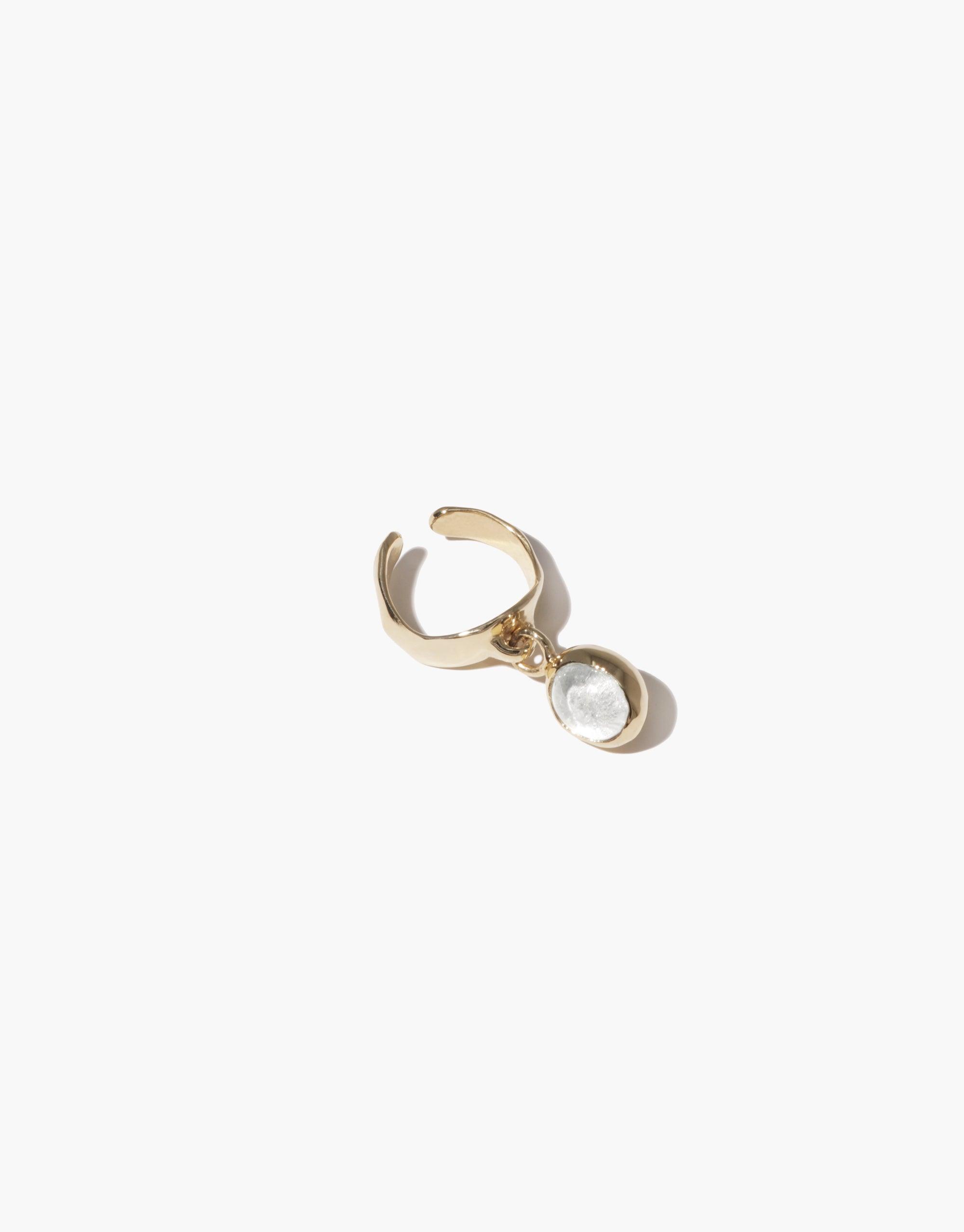 Oval Dangling Ear Cuff featuring a gold-toned cuff with a delicate transparent charm. Handcrafted from upcycled glass, this eco-friendly jewelry piece offers a unique and sustainable accessory option. Ideal for those seeking elegant, environmentally conscious fashion. CLED
