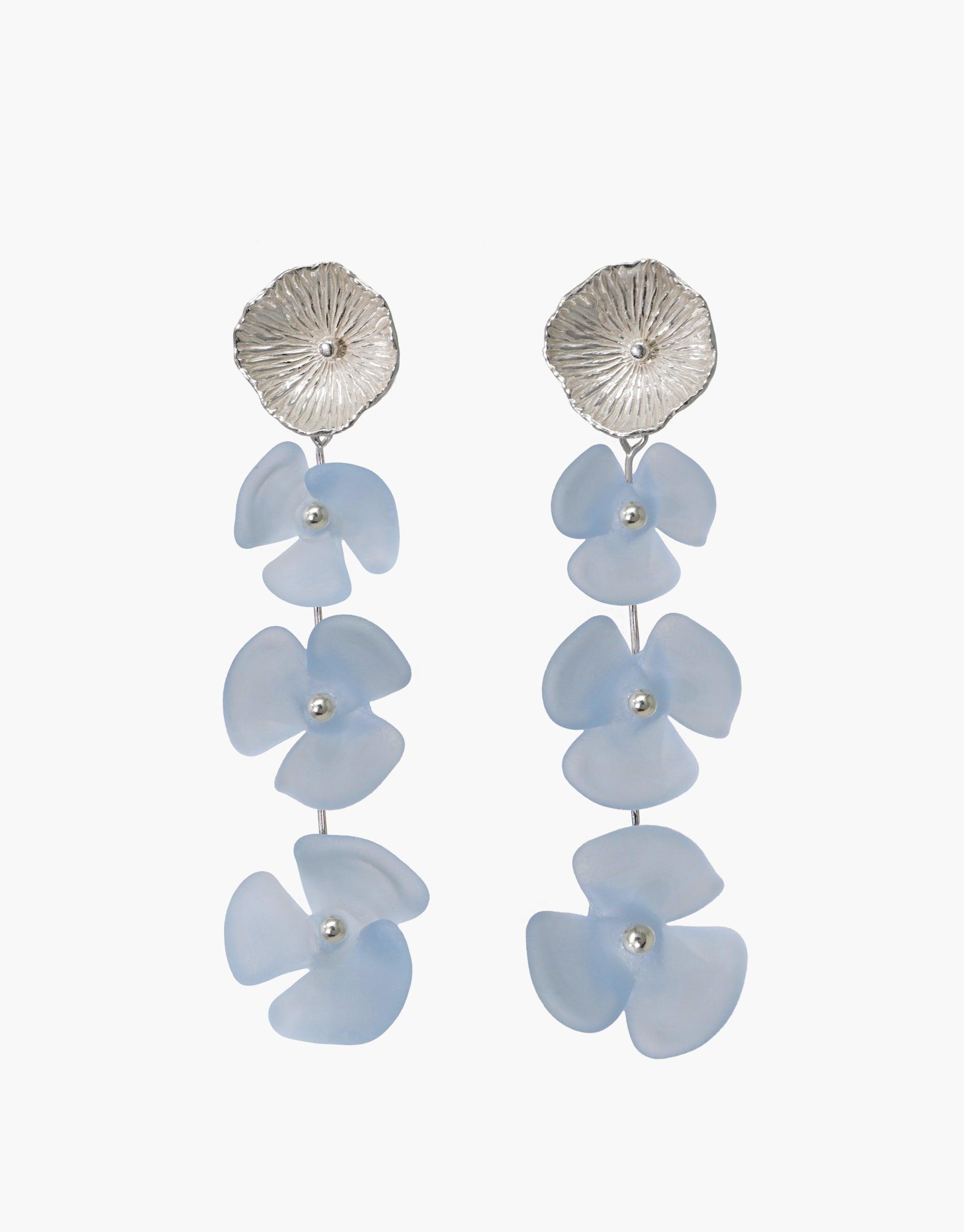 Elegant Periwinkle Trio Earrings featuring silver circular studs with cascading light blue glass flower drops. Handcrafted eco-friendly design showcasing three delicate floral elements. Perfect for a sophisticated, sustainable style statement. Made from repurposed glass bottles. CLED Periwinkle Trio Earrings.