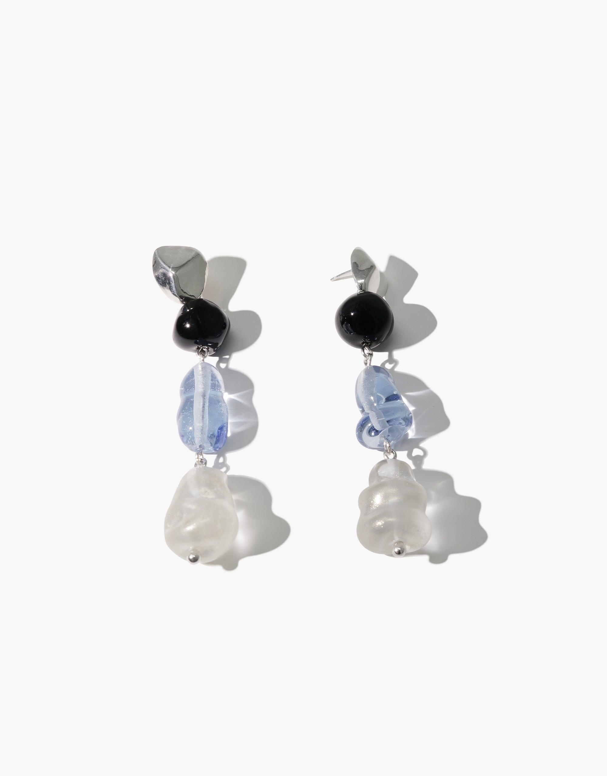 Blue Pearl Earrings featuring elegant drop design with silver stud, black bead, light blue glass, and white pearl-like element. Handcrafted eco-friendly jewelry inspired by Blue Jay bird. Stylish and sustainable accessory for any outfit. CLED