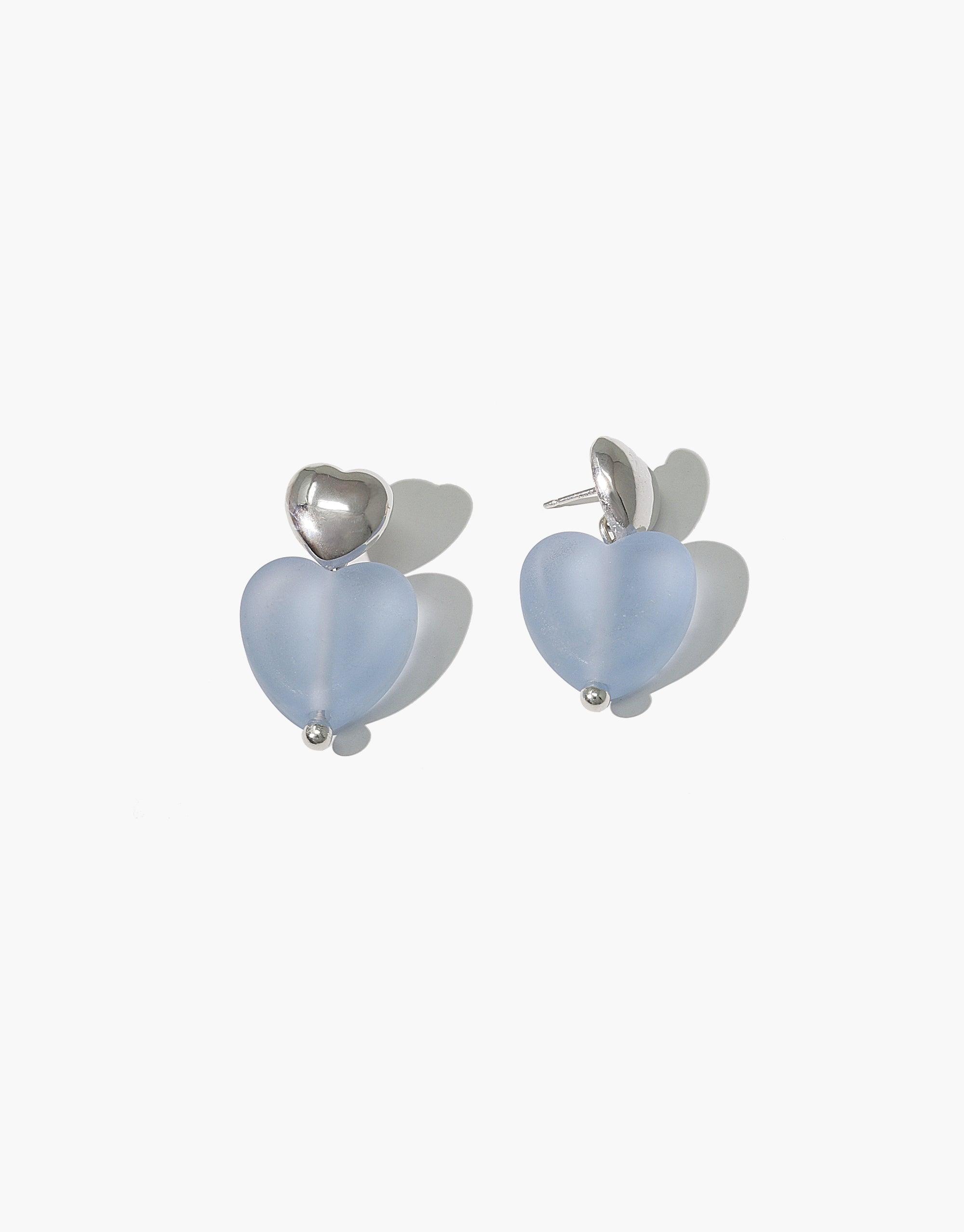 Love Earrings with Large Heart Drop featuring matte blue jay eco gems in heart shapes. Sterling silver studs with dangling heart-shaped recycled glass drops. Handcrafted sustainable jewelry with a romantic design. Elegant and eco-friendly accessory by CLED.