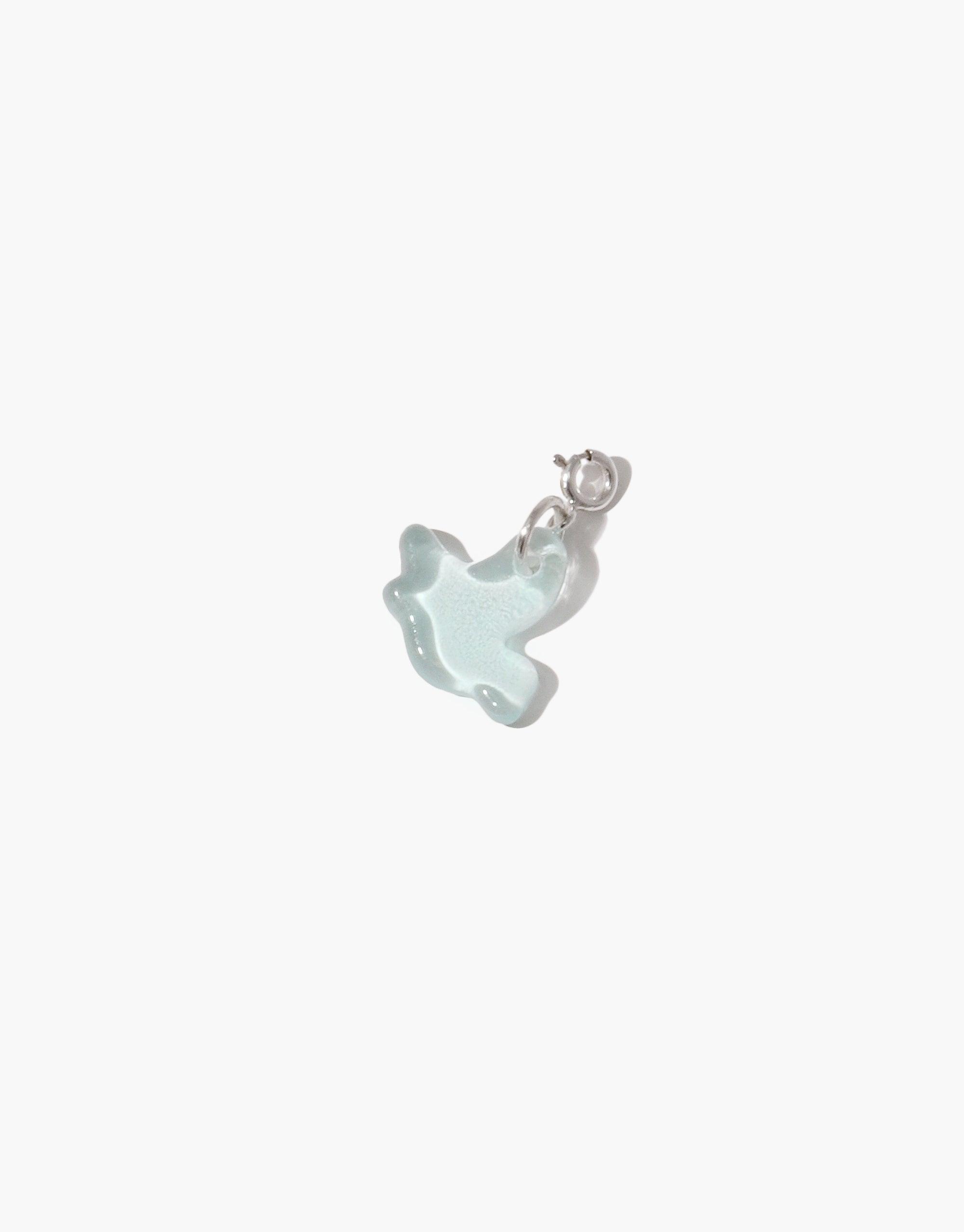Delicate light blue glass bird charm with silver clasp, handcrafted from upcycled eco-friendly material. Perfect addition to necklaces or bracelets. Bird | Icon Charm by CLED.