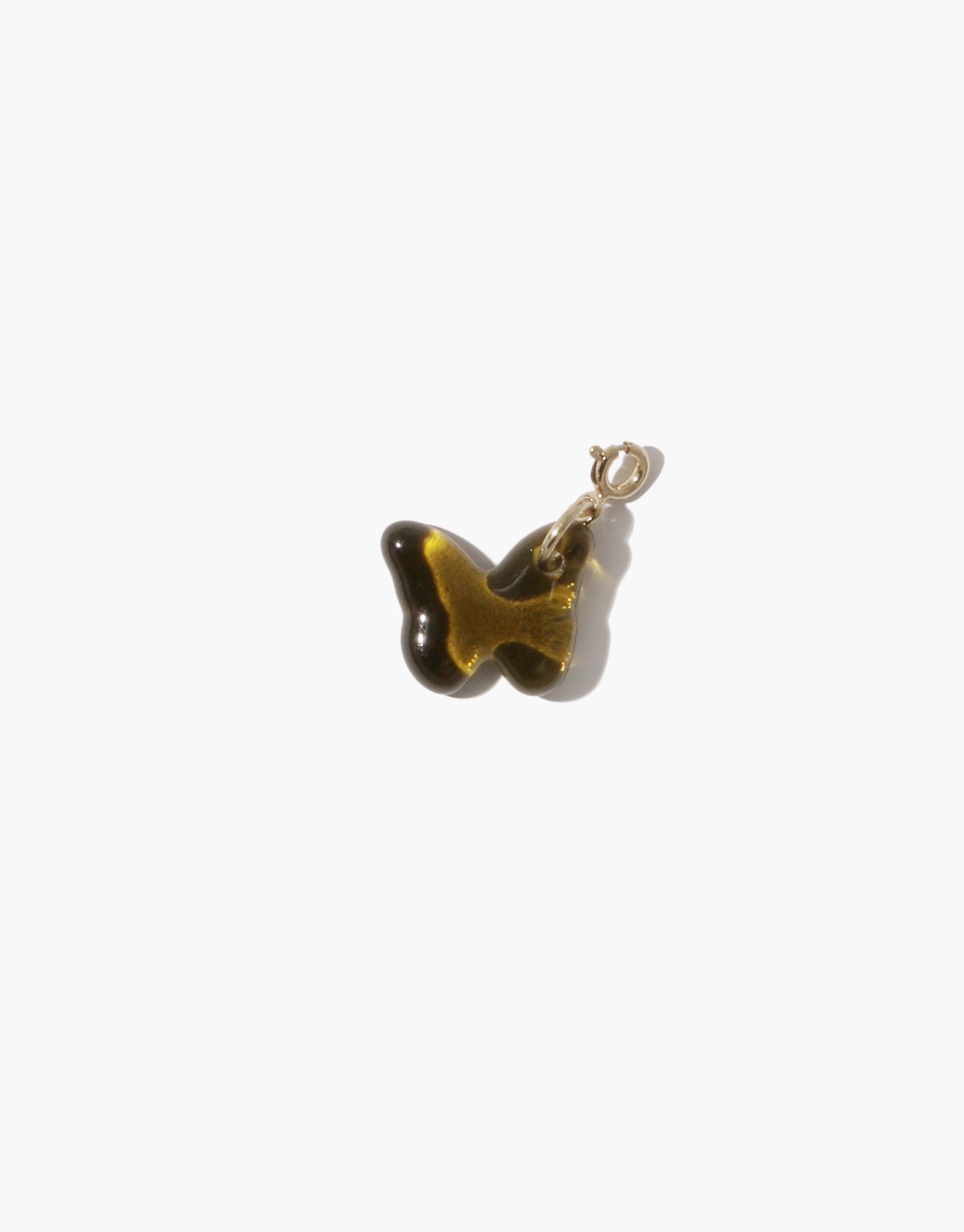 Delicate amber-colored glass butterfly charm with silver attachment, handcrafted from upcycled bottle glass. Perfect addition to necklaces or bracelets. Butterfly | Icon Charm by CLED.