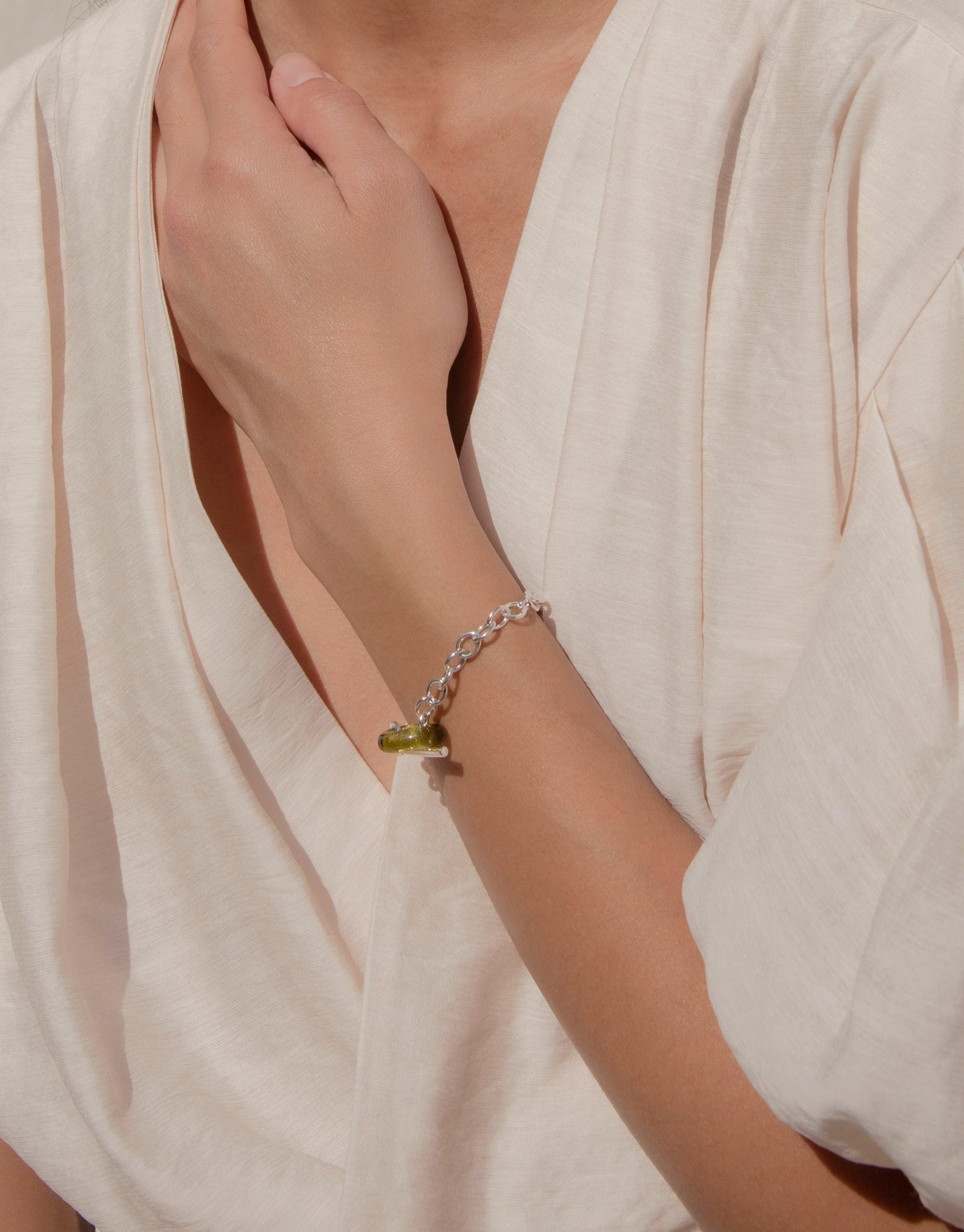 Elegant ITL Toggle Bracelet with interlocking links and eco gem, showcased on a model's wrist against a light background. Handcrafted sustainable jewelry piece by CLED, available in sterling silver or gold vermeil.