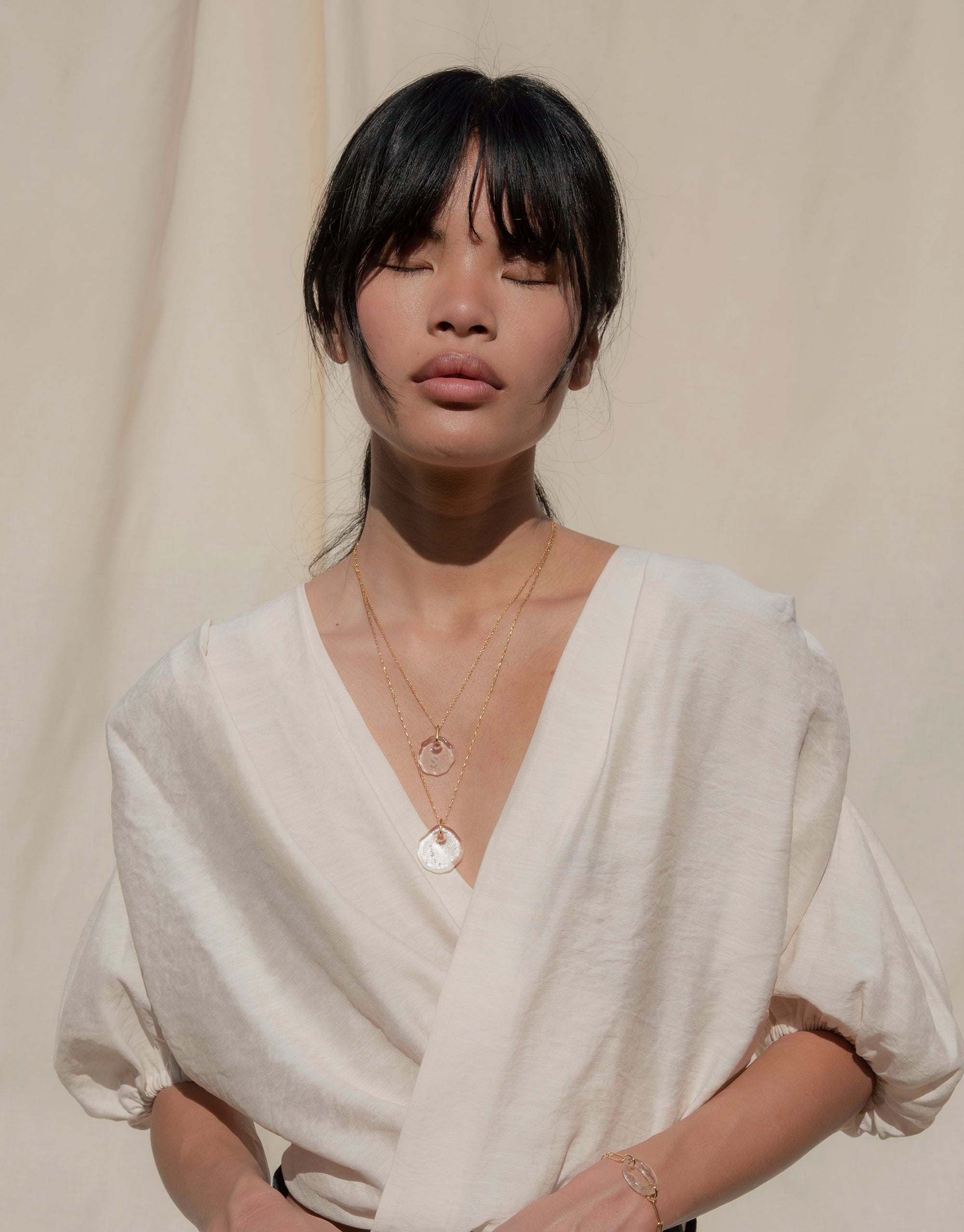 Elegant model wearing Constellation Necklace, featuring delicate glass pendant with engraved zodiac symbols on adjustable chain. Eco-friendly jewelry showcasing sustainable luxury and celestial design. Perfect for expressing connection and love. Handmade in Los Angeles by CLED.