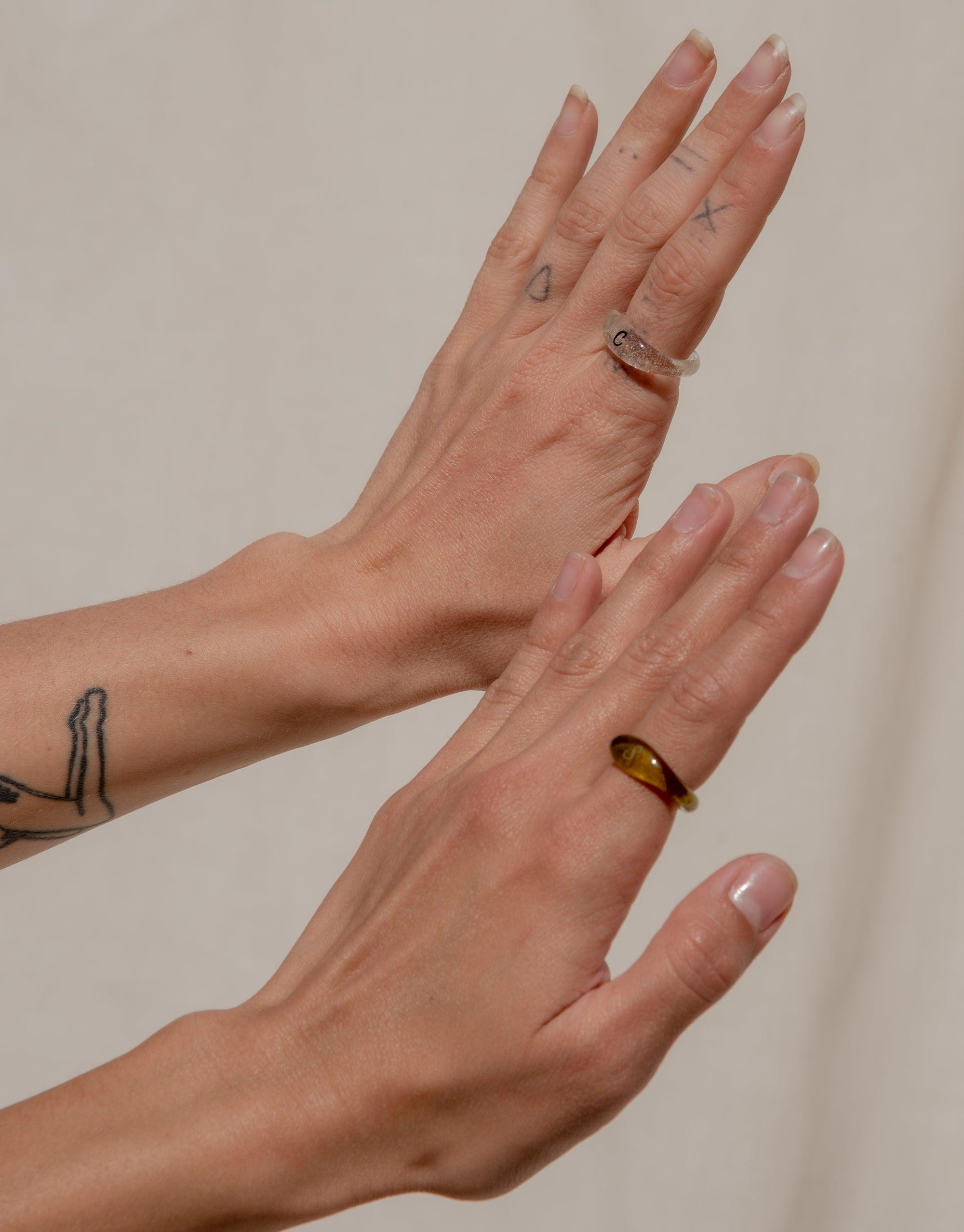Hands modeling Engravable Signet Ring from the Messenger Collection, showcasing personalized eco-friendly glass rings in different colors and styles, perfect for sharing meaningful messages and connecting with loved ones. Handmade in Los Angeles by CLED.