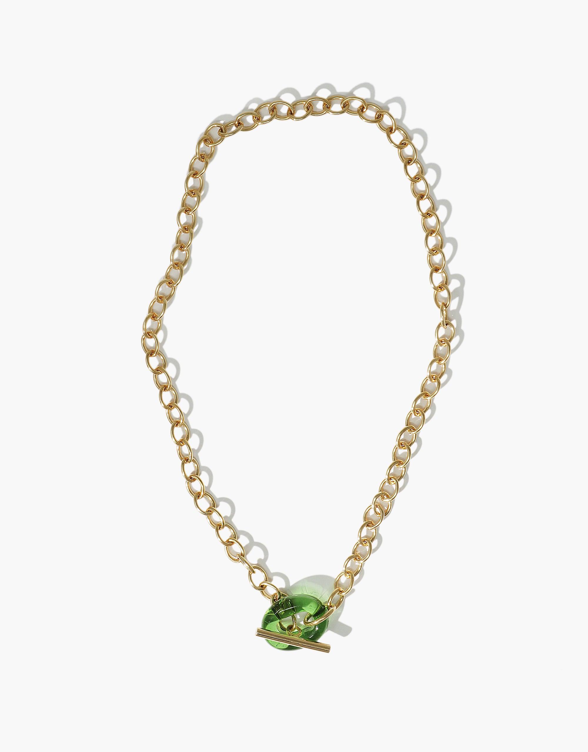 ITL Toggle Choker Necklace featuring gold-colored interlocking chain links with a green eco gem toggle clasp. Handcrafted sustainable jewelry piece showcasing elegant design and eco-friendly materials. Perfect for stylish and environmentally conscious individuals. CLED