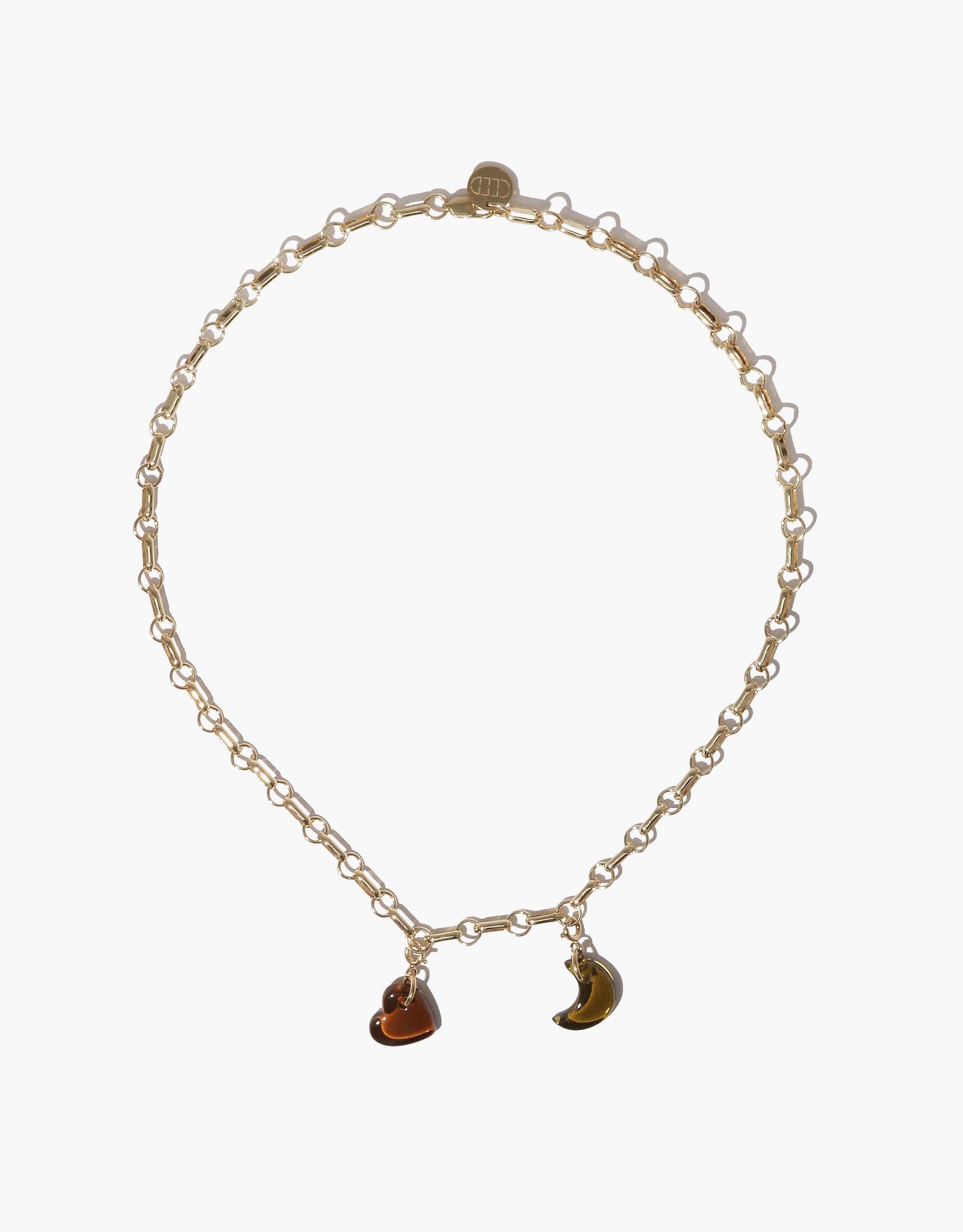 Gold-toned delicate chain necklace with two hanging charms - a heart and a crescent moon shape. Elegant and minimalist design perfect for layering or wearing alone. Moon | Icon Charm by CLED.