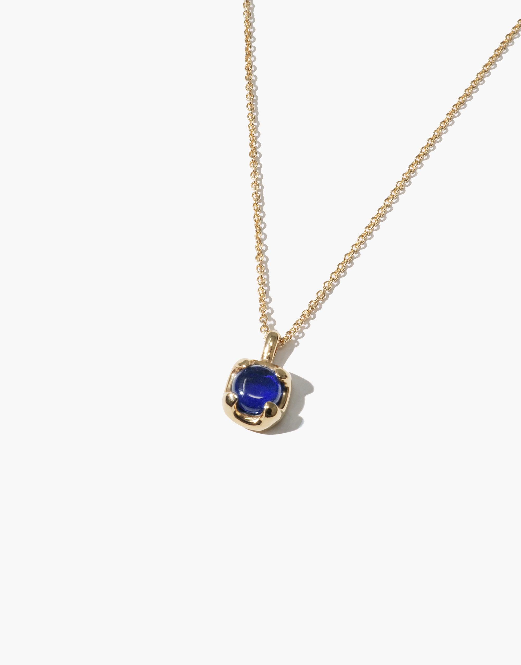 Elegant Beam Necklace featuring a delicate gold chain with a vibrant blue eco gem pendant, showcasing sustainable luxury and prismatic beauty. Handcrafted design inspired by rays of light, perfect for eco-conscious fashion lovers. CLED