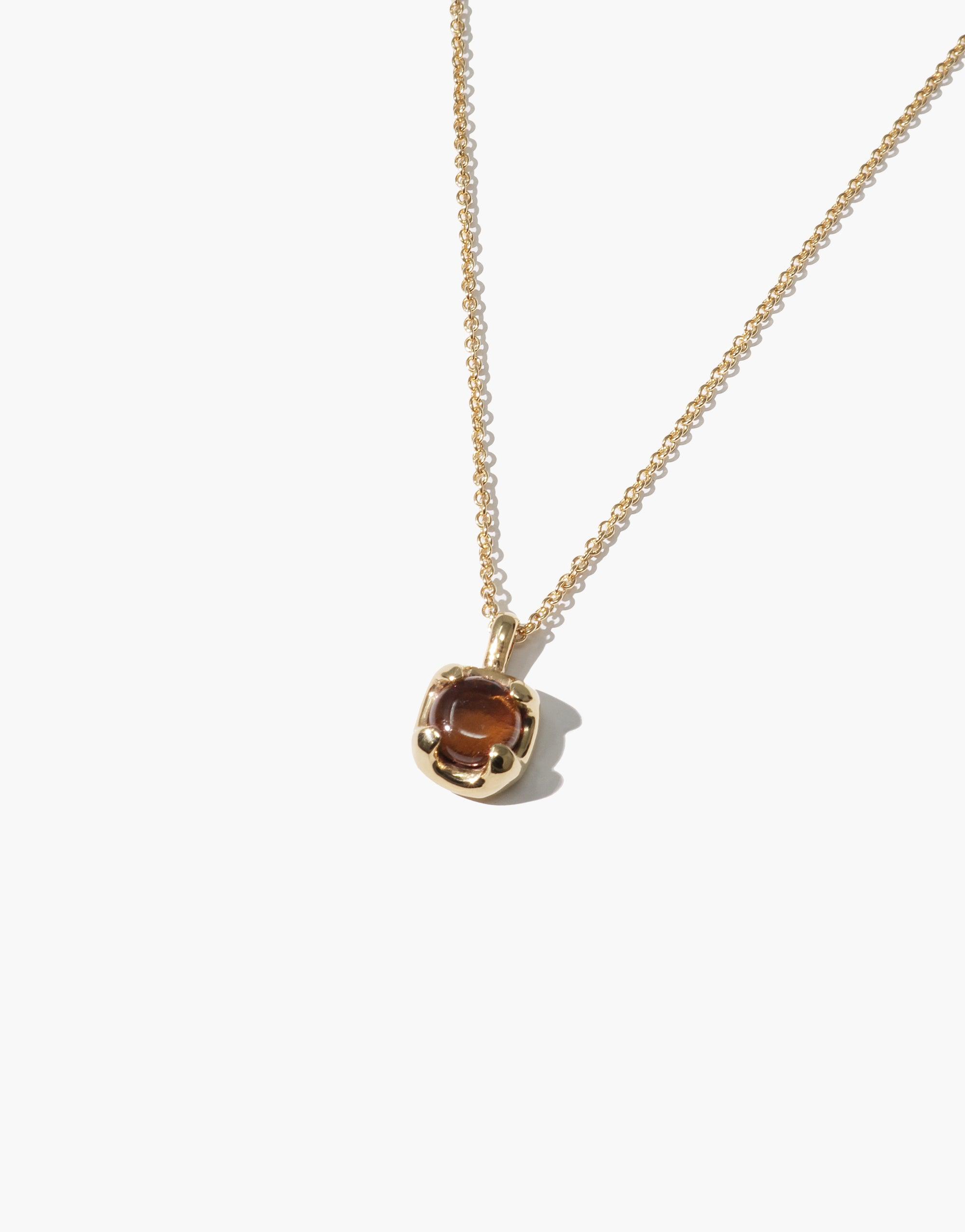 Elegant gold-toned necklace featuring a delicate pendant with a warm amber-colored eco gem, showcasing sustainable luxury and minimalist design. Beam Necklace by CLED.