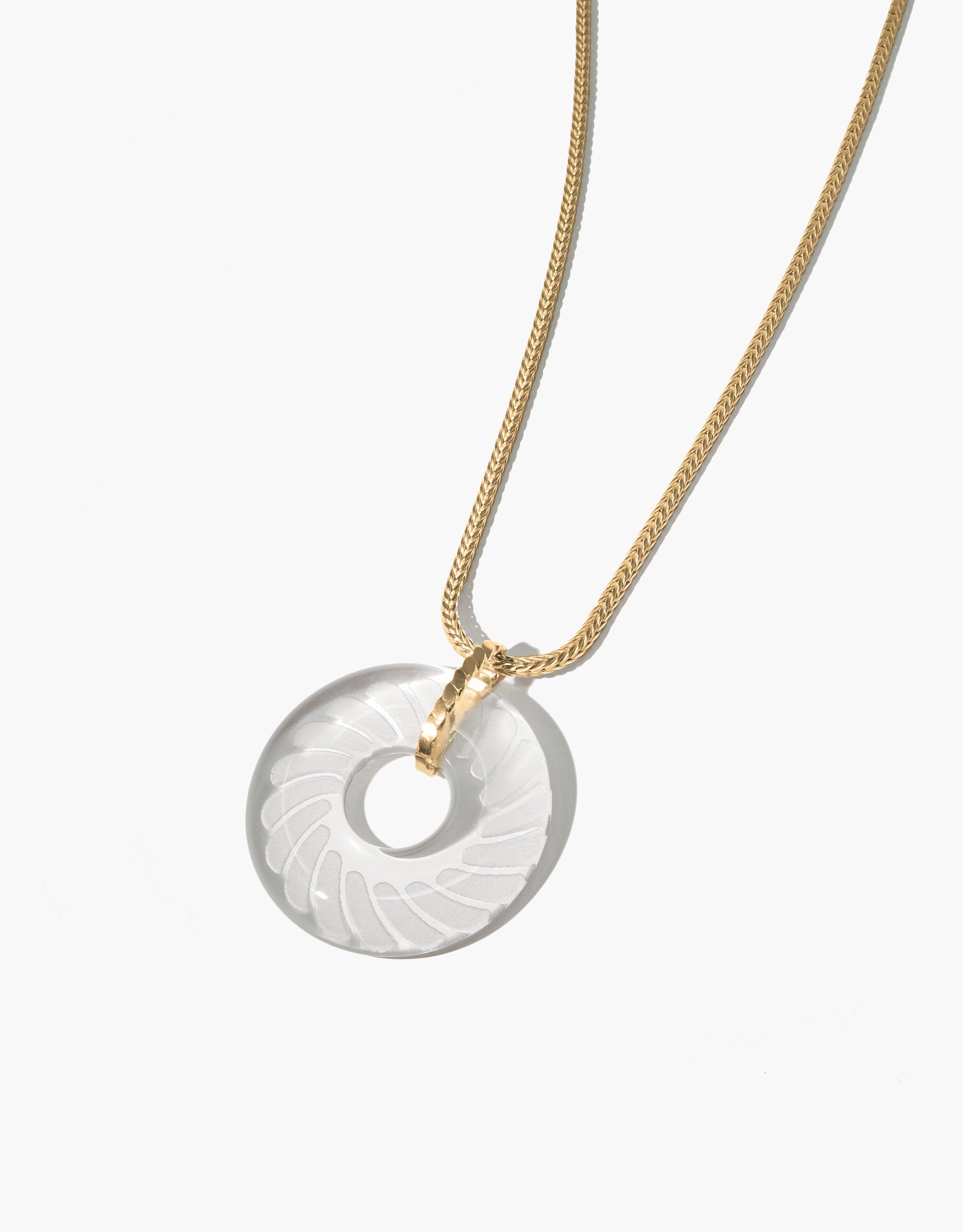 Elegant Braid Necklace featuring a circular eco gem pendant with engraved braid pattern, suspended on a delicate gold chain. Handcrafted from repurposed glass, this sustainable jewelry piece showcases intricate detailing and eco-conscious design. CLED Braid Necklace
