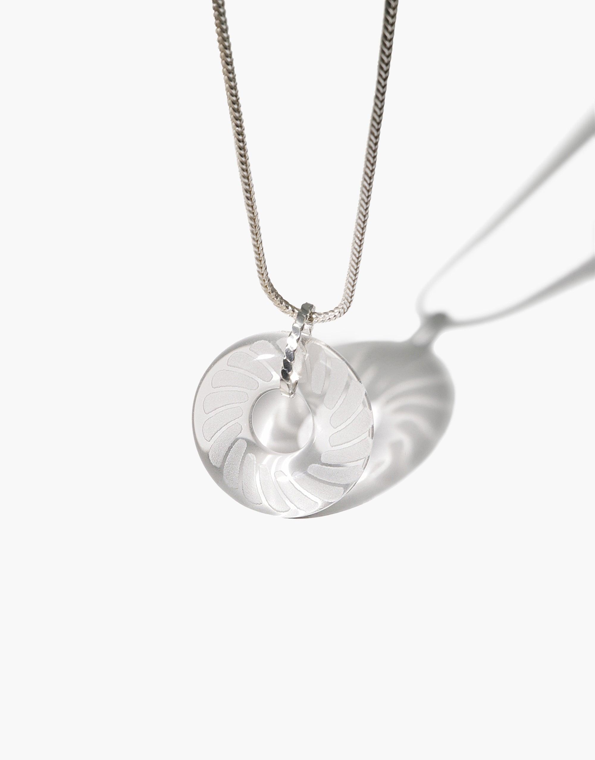 Braid Necklace featuring a clear eco gem pendant with engraved braid pattern, suspended on a delicate silver chain. Handcrafted from repurposed glass, this sustainable jewelry piece showcases elegant design and eco-conscious craftsmanship. CLED