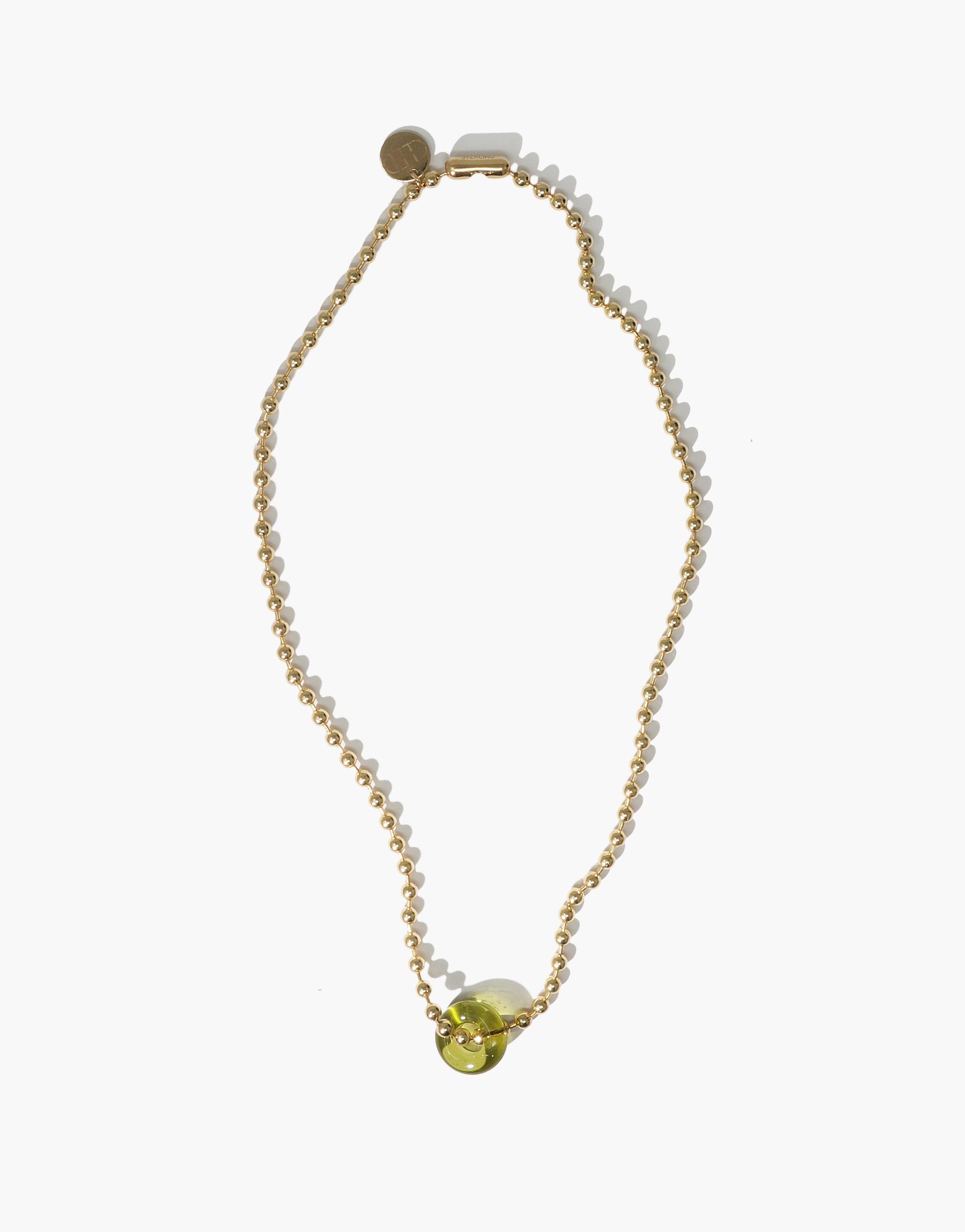 Elegant Donut Ball Necklace featuring a gold-tone chain with small white beads and a unique yellow-green eco gem pendant, showcasing sustainable luxury and prismatic beauty. Handcrafted by CLED.