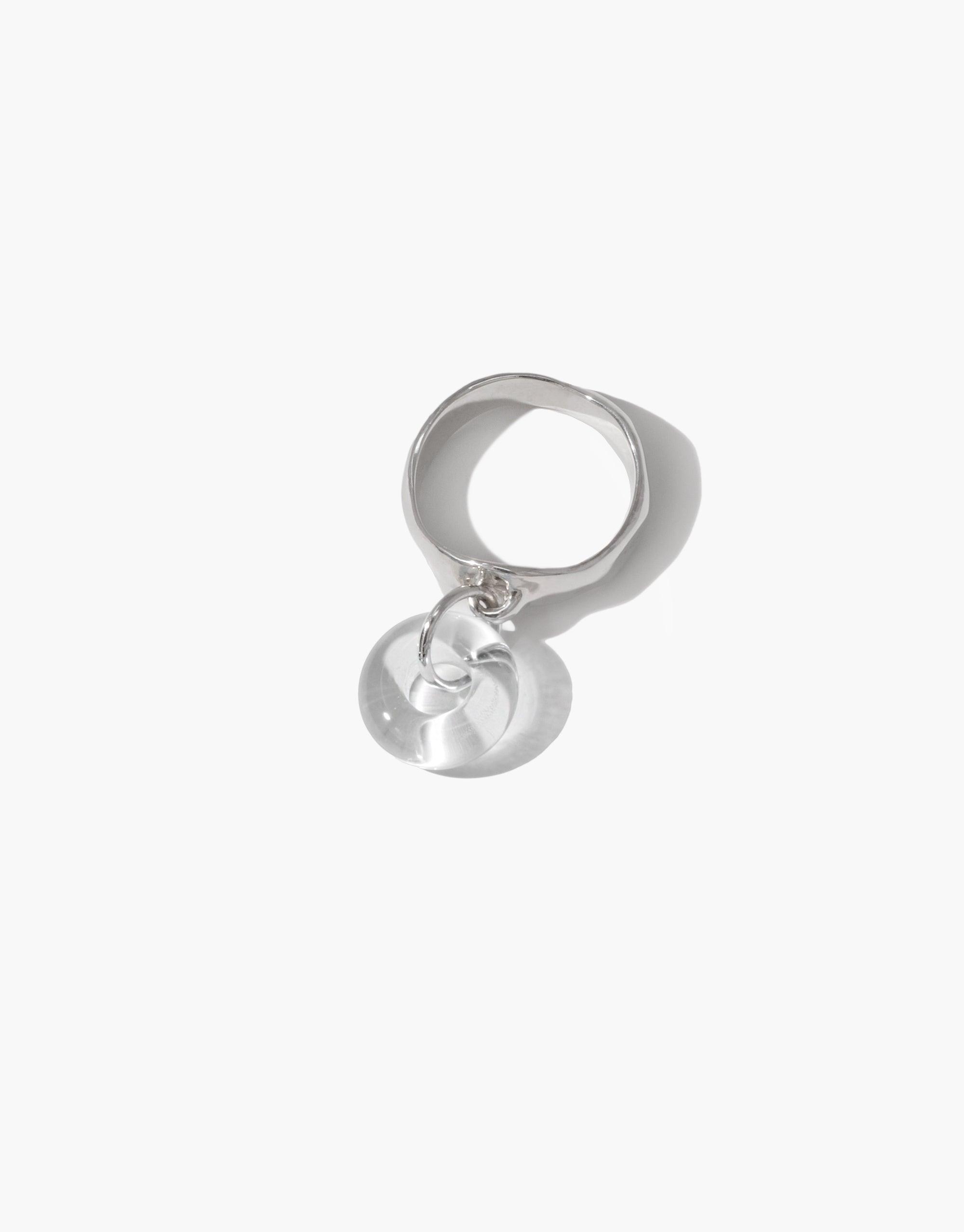 Elegant sterling silver ring with dangling circular eco charm, showcasing unique and playful design. Handcrafted from upcycled glass, this Donut Dangling Ring embodies sustainable luxury and environmental consciousness. CLED