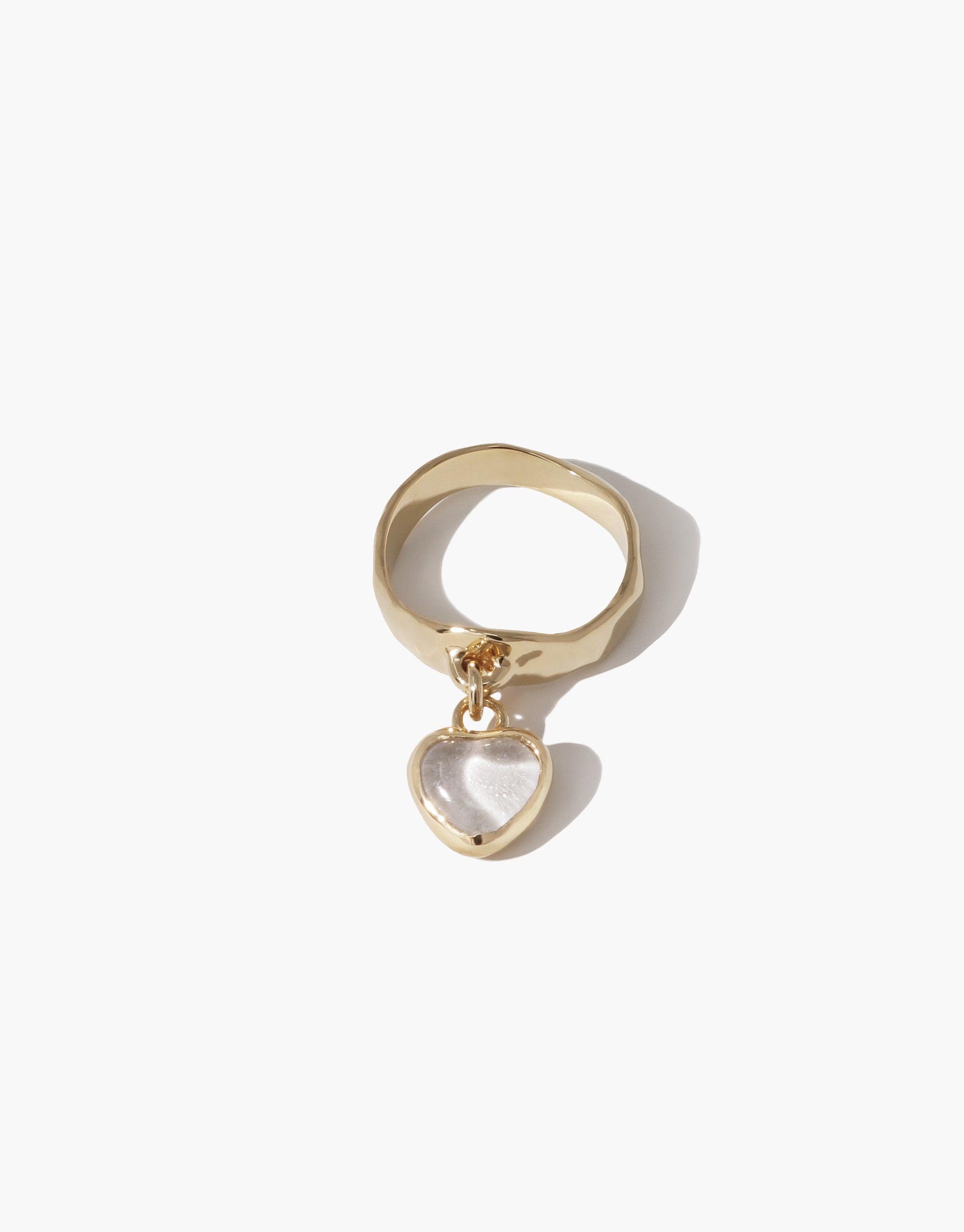 Heart Dangling Ring featuring a gold-toned band with a translucent heart-shaped charm suspended from it. The charm appears to be made of upcycled glass, showcasing a unique and eco-friendly design. This handcrafted piece exemplifies sustainable jewelry by CLED.