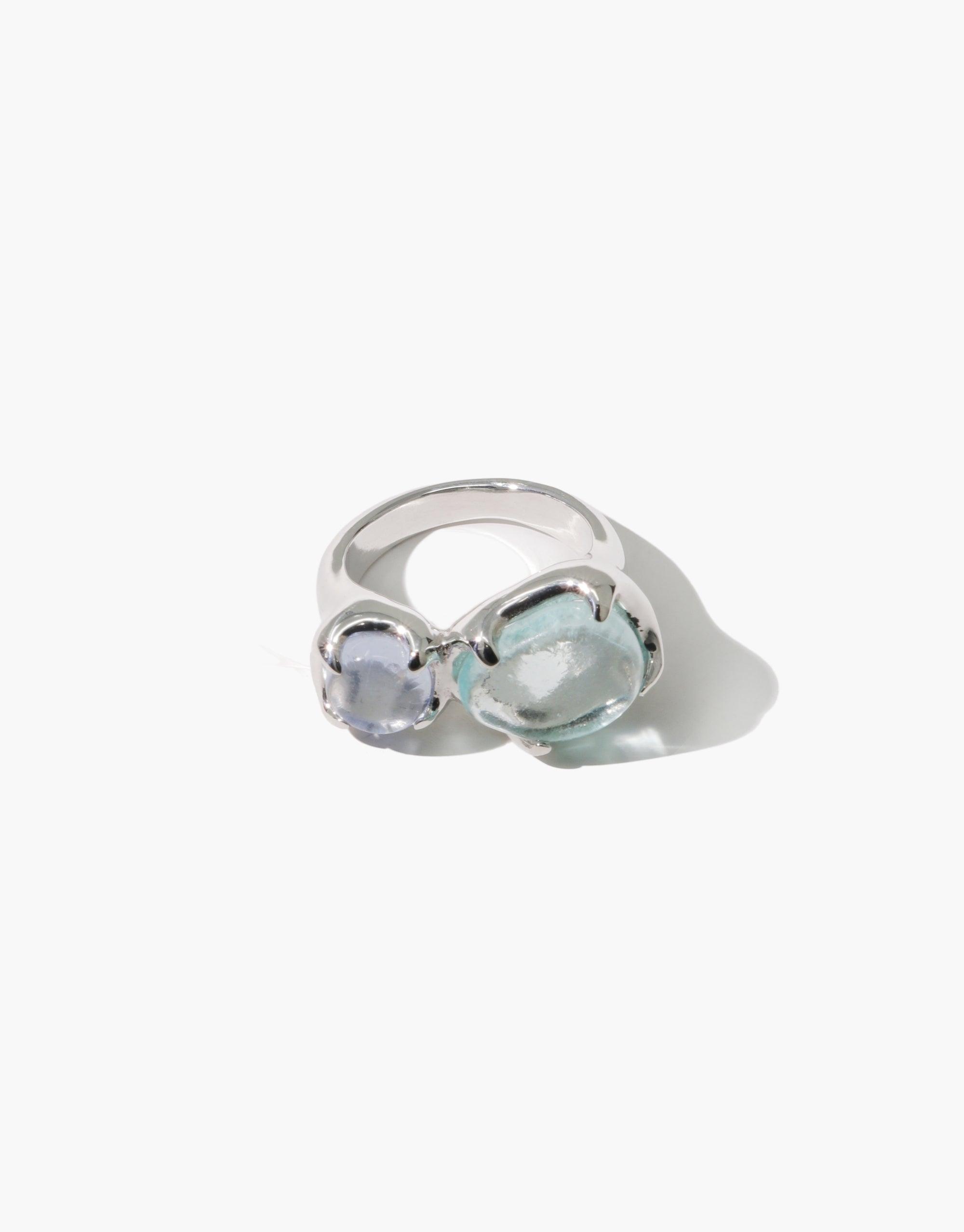Duo Beam Ring featuring two eco gems in soft blue and clear tones, set on a sleek silver band. Handcrafted jewelry with upcycled glass, showcasing sustainable luxury and prism-inspired design. Eco-friendly statement piece by CLED.