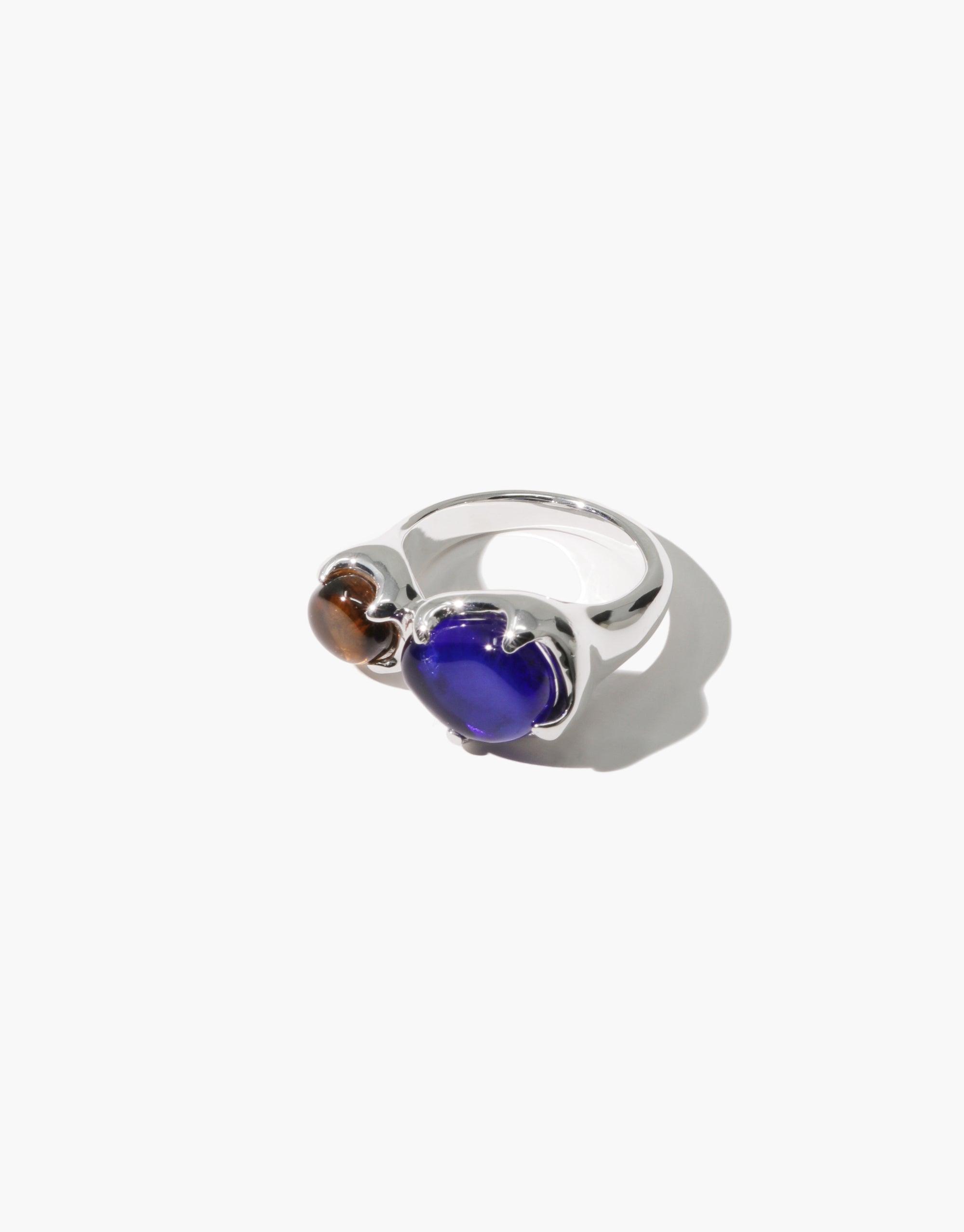 Duo Beam Ring featuring two eco gems in blue and amber, set in a sleek silver band. Unique handcrafted design showcasing upcycled glass, embodying sustainable luxury. Versatile statement piece for eco-conscious fashion lovers. CLED