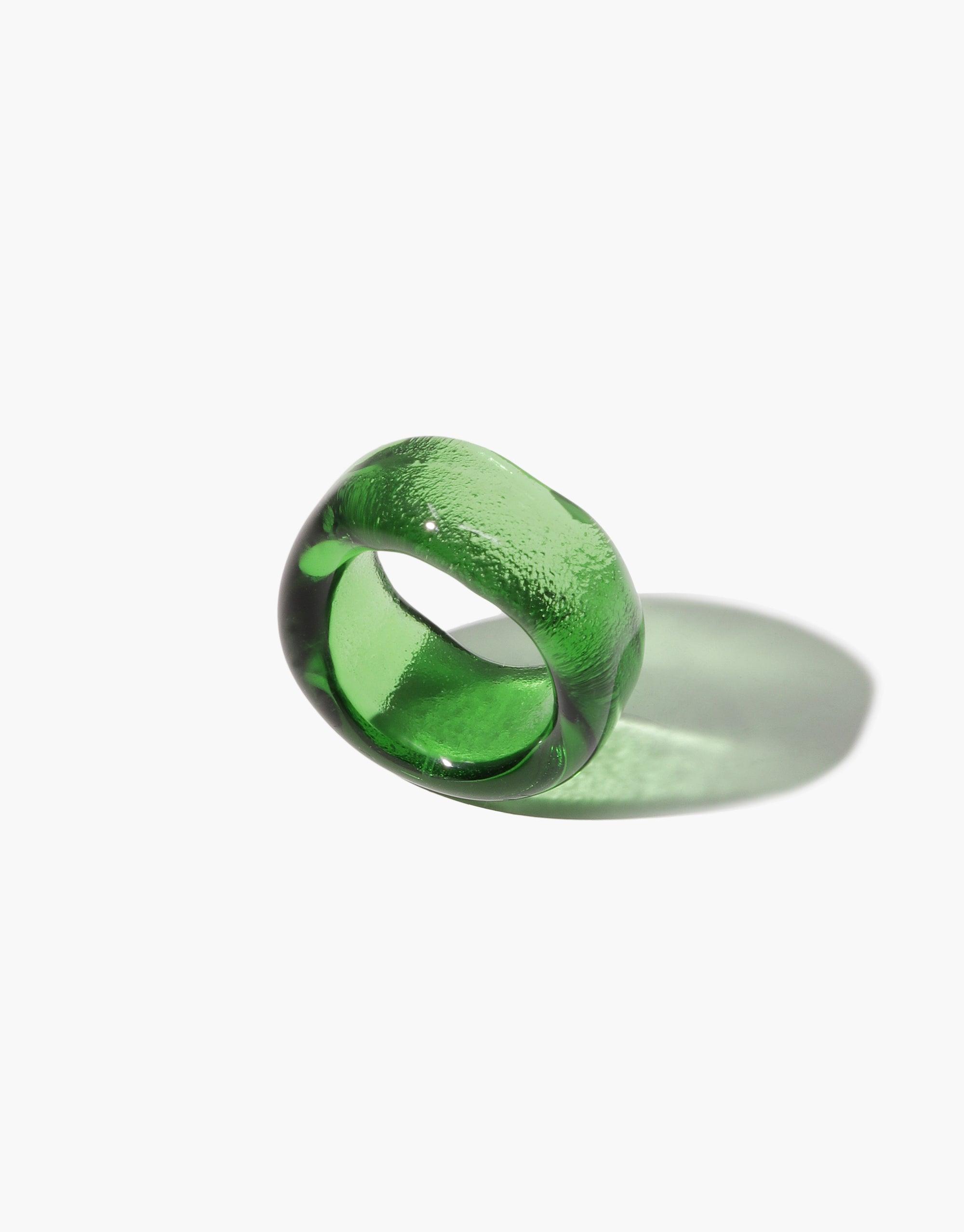 Wave Ring: A hand-formed green wavy ring, crafted from discarded glass bottle, showcasing a smooth, polished finish on a white surface, embodying CLED's eco-conscious design.