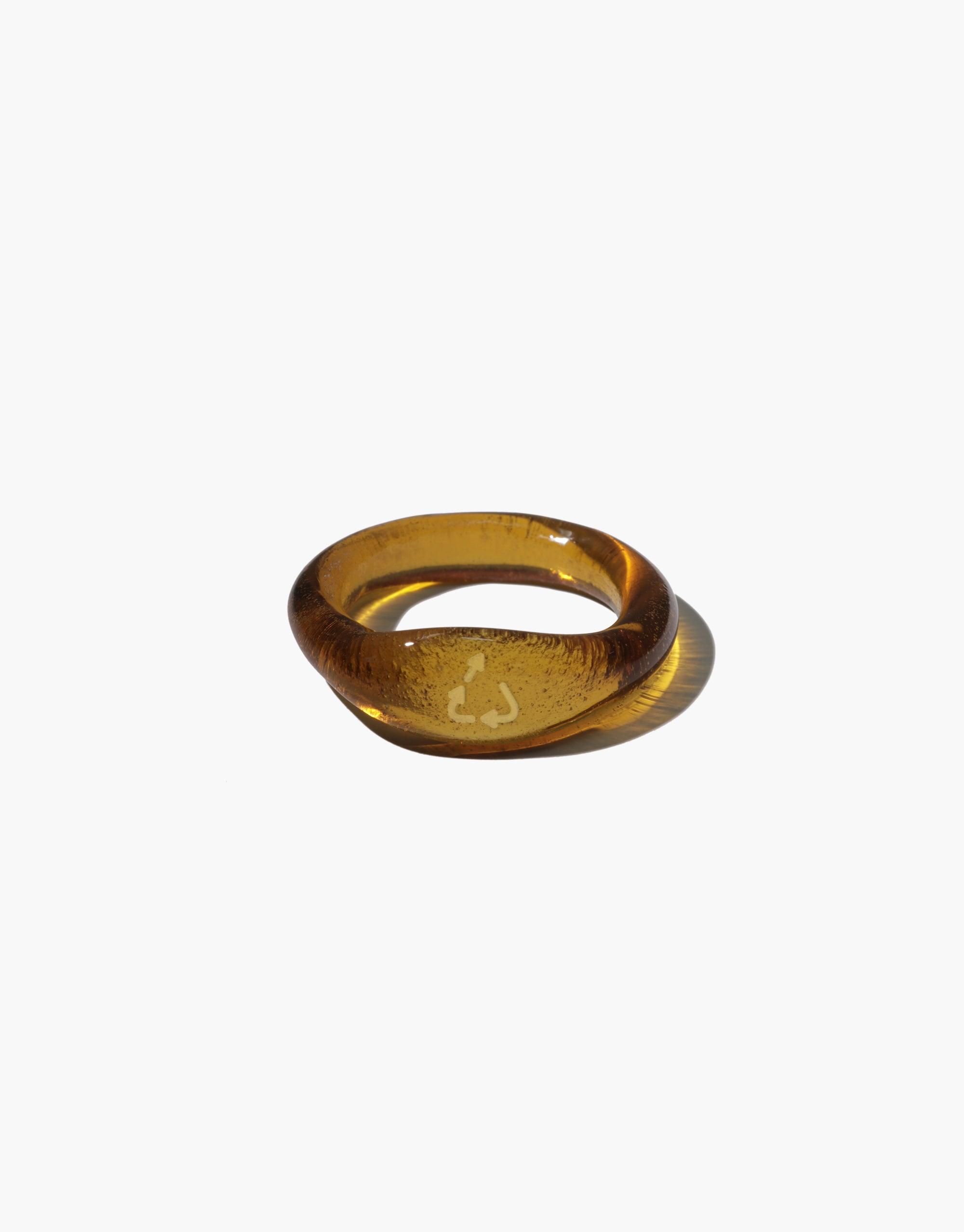 Upcycle Signet Ring featuring a clear engraved upcycling sign design on a brown amber ring hand-formed from discarded glass. Reflects CLED's eco-conscious craftsmanship and connection-themed Messenger Collection.