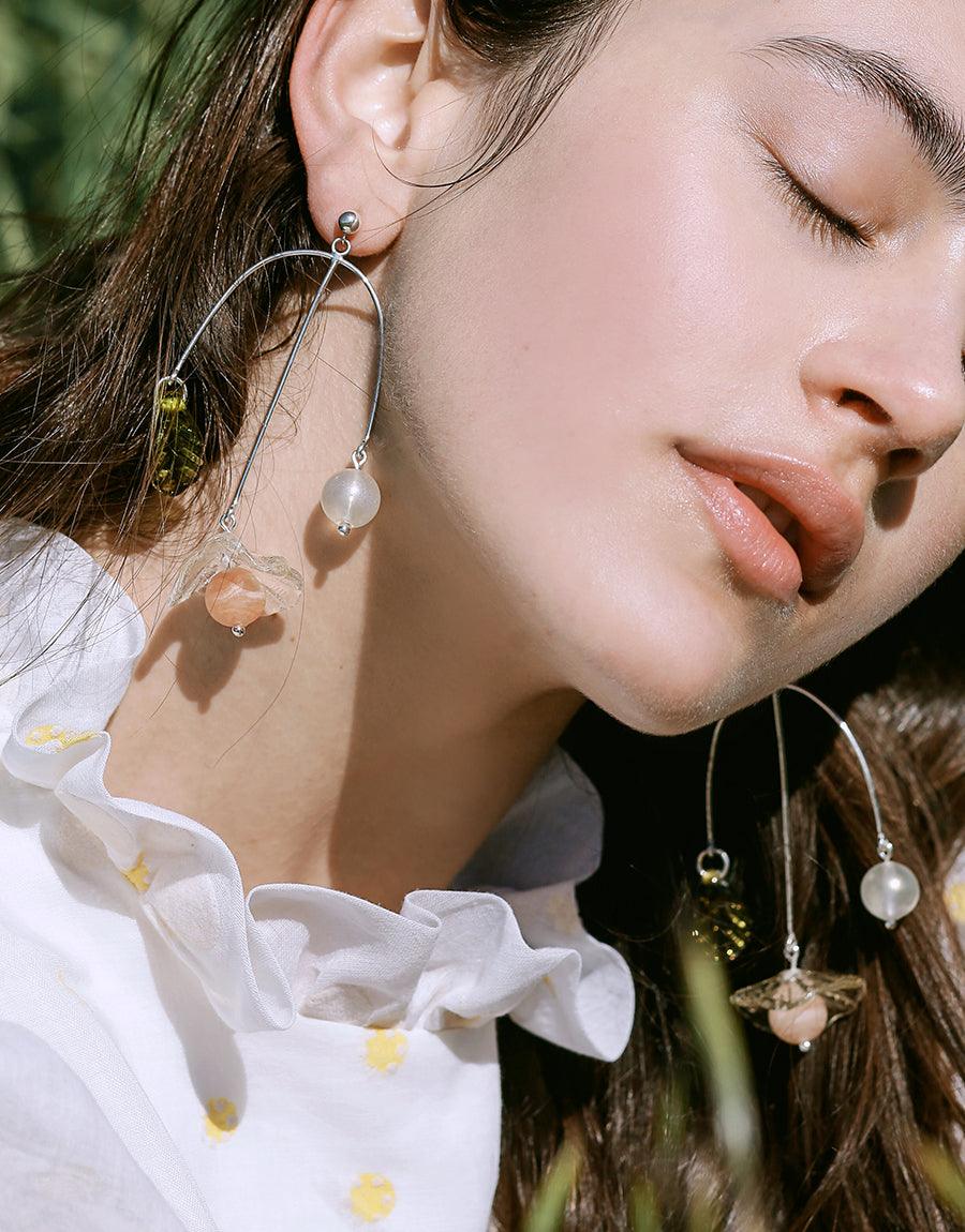 Elegant Floral Cluster Earrings showcasing delicate eco-friendly glass accents on sterling silver hoops, worn by a model in a serene outdoor setting. Handcrafted sustainable jewelry perfect for sunny day accessories. CLED