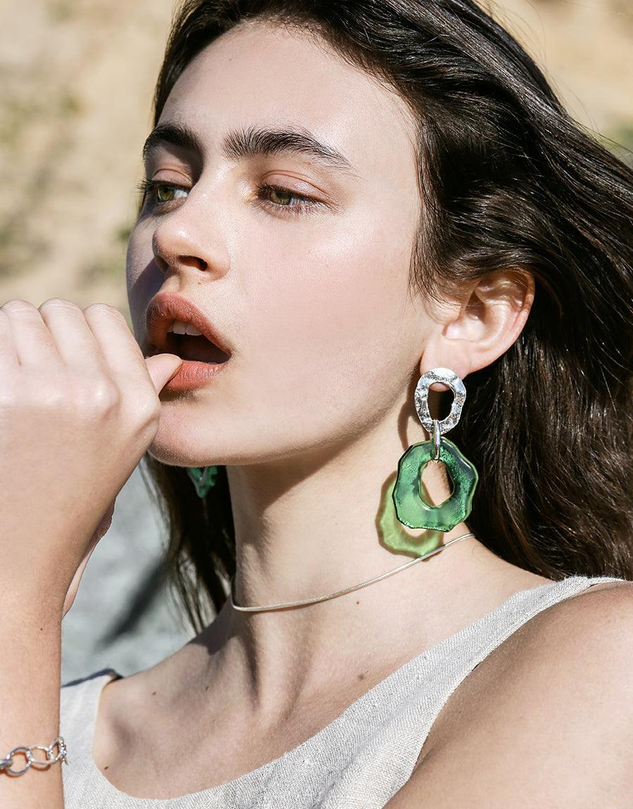 Elegant model wearing High Tide Earrings, showcasing green eco-friendly glass drop design. Sterling silver, ocean-inspired statement piece for casual or formal wear. Handcrafted in Los Angeles. CLED, High Tide Earrings.