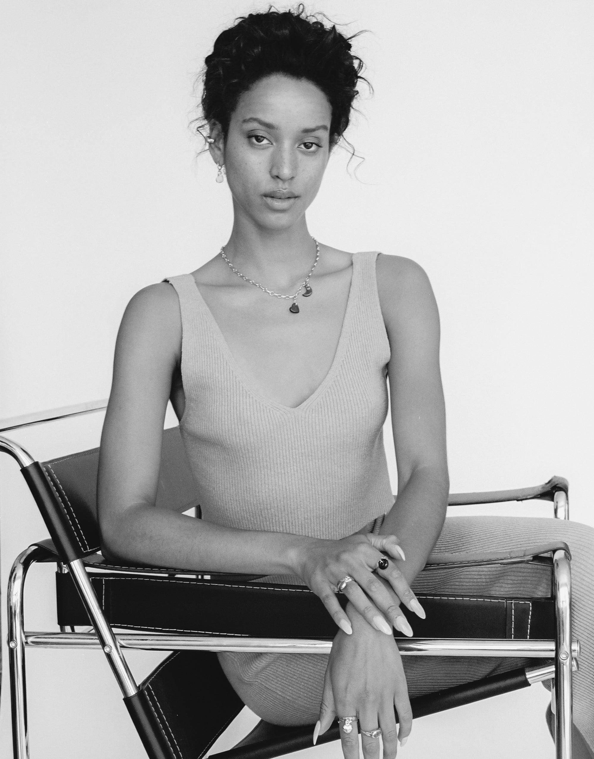 Black and white portrait of a model wearing a sleek tank top and delicate necklace, showcasing the Moon Icon Charm. The elegant jewelry piece complements the minimalist style, highlighting CLED's Moon | Icon Charm.