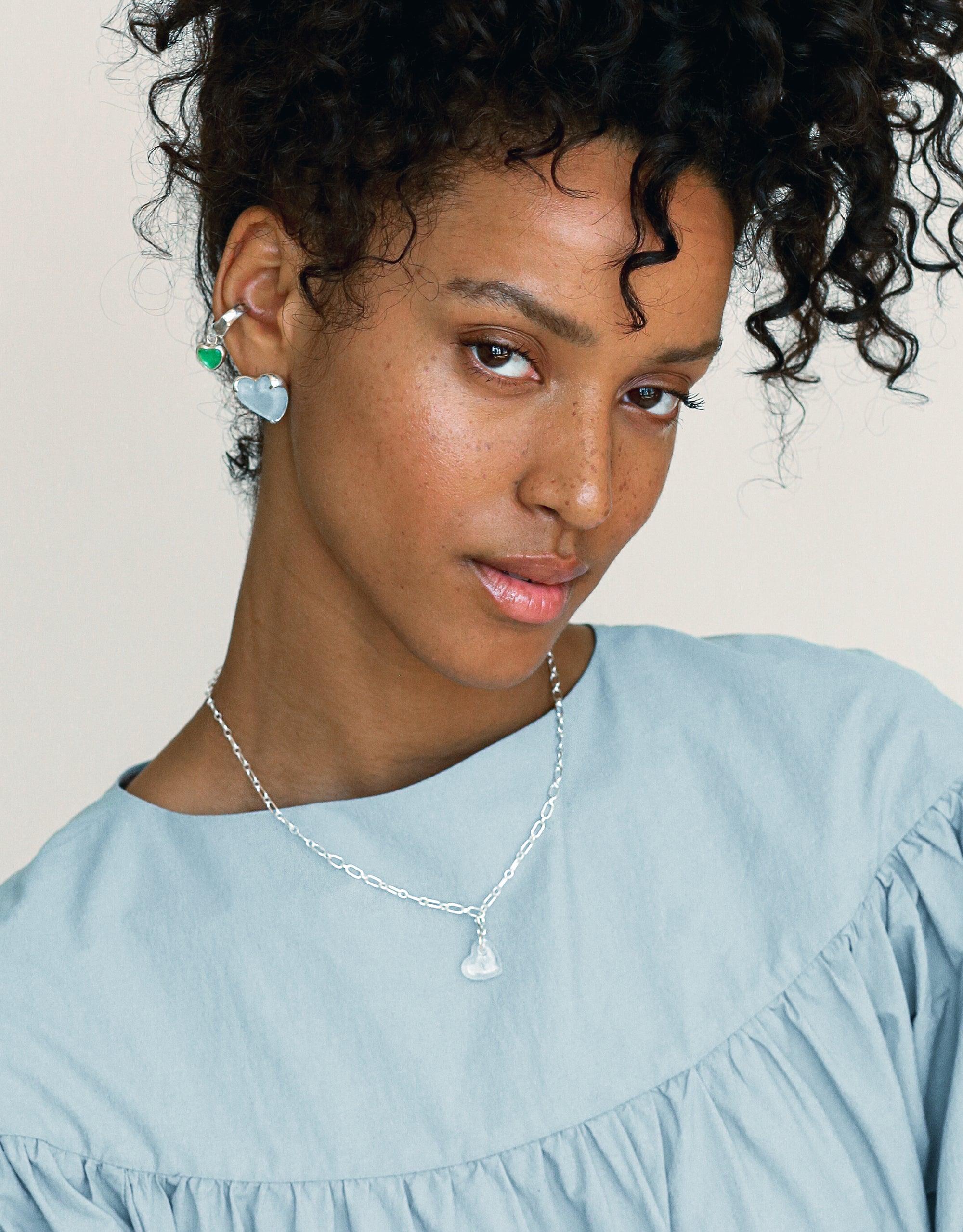 Elegant silver Icon Chain Necklace | B with delicate pendant, worn by model in light blue top. Versatile jewelry piece for customizable style. Perfect for layering or solo wear. Sustainable fashion accessory by CLED.
