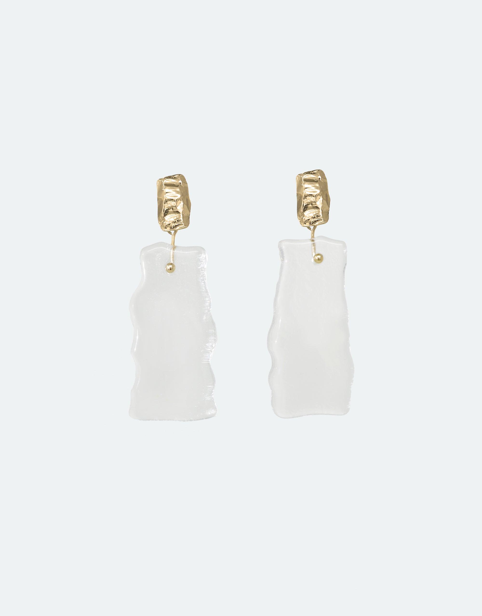 Elegant Afloat Earrings featuring hand-formed eco gem pendants in translucent white, resembling melting ice sheets, suspended from textured gold vermeil studs. Sustainable, climate change-inspired jewelry from the Floating Glacier Collection by CLED.