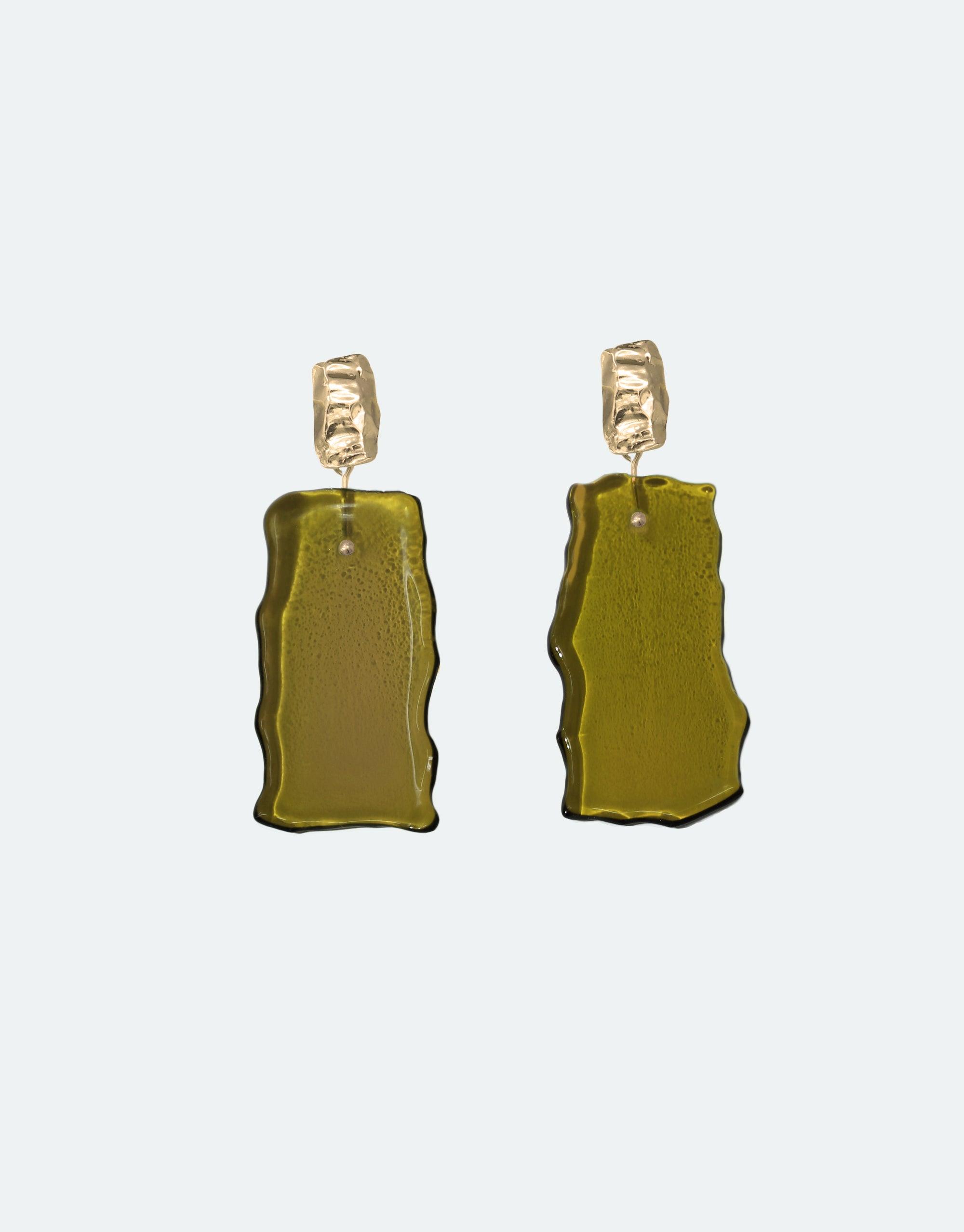 Afloat Earrings featuring organic, hand-cut olive green glass pendants inspired by melting ice sheets, suspended from textured gold vermeil studs. Eco-friendly, handmade jewelry showcasing climate change awareness. Elegant and unique design by CLED.