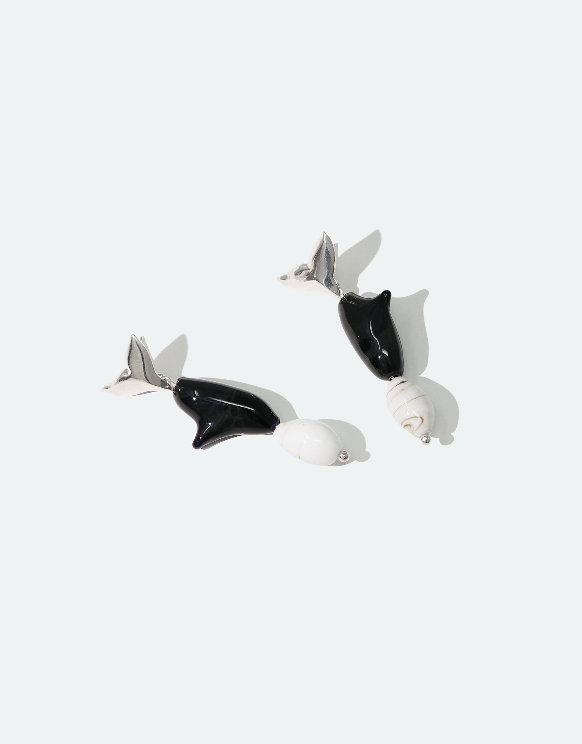 Elegant Orca Earrings featuring black and white whale-shaped pendants with silver tails, showcasing the beauty of marine life. Handcrafted eco-friendly jewelry from the Floating Glacier Collection, raising awareness for endangered species and climate change. CLED Orca Earrings.